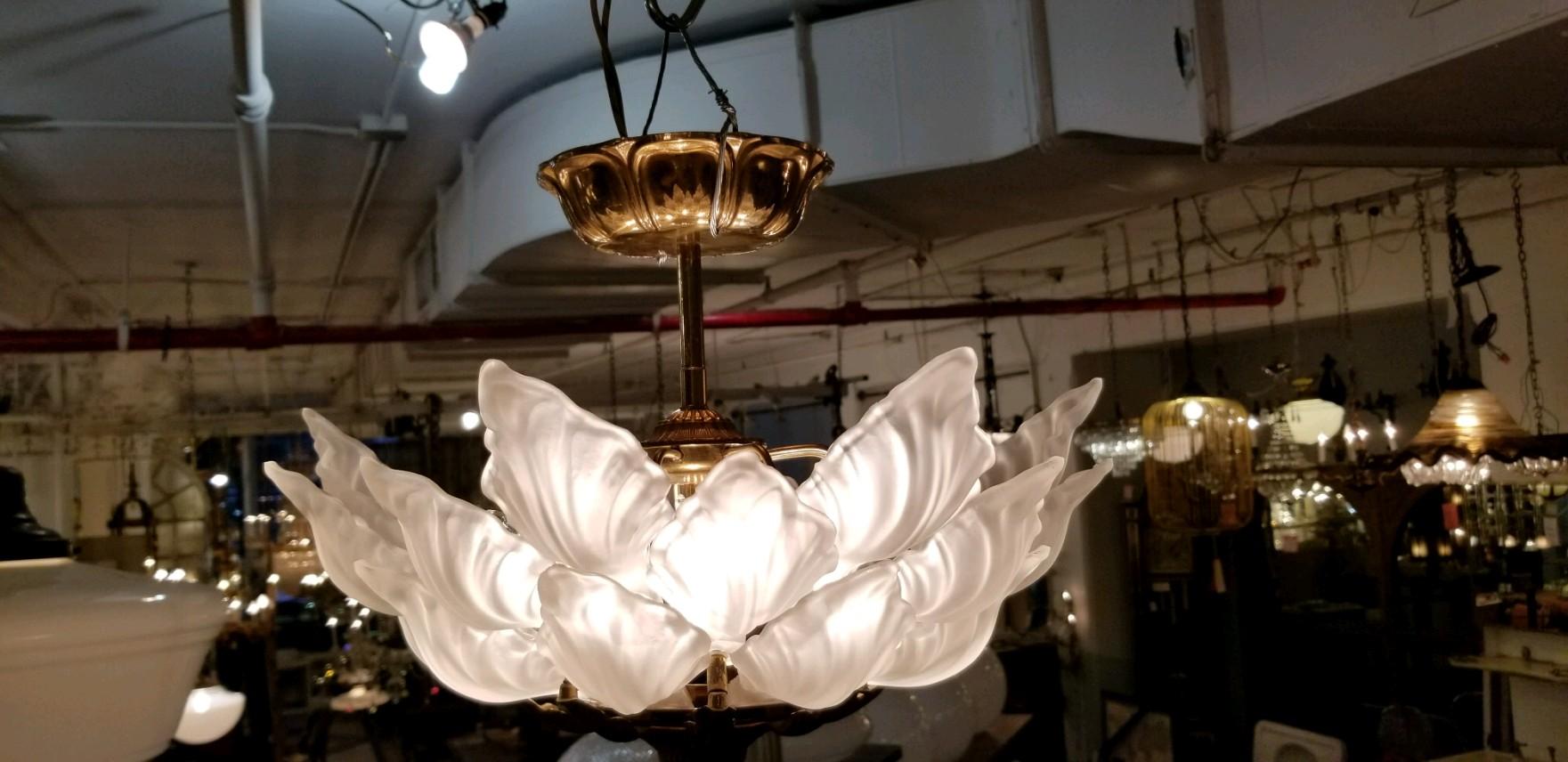 1931 large scale Alba Macbeth Evans white petal ceiling fixture made of cast glass with a heavy brass fitter. Three tiers of leaves with five sockets. Semi flush mount. These lights adorned various suites of the Towers of the NYC Waldorf Astoria