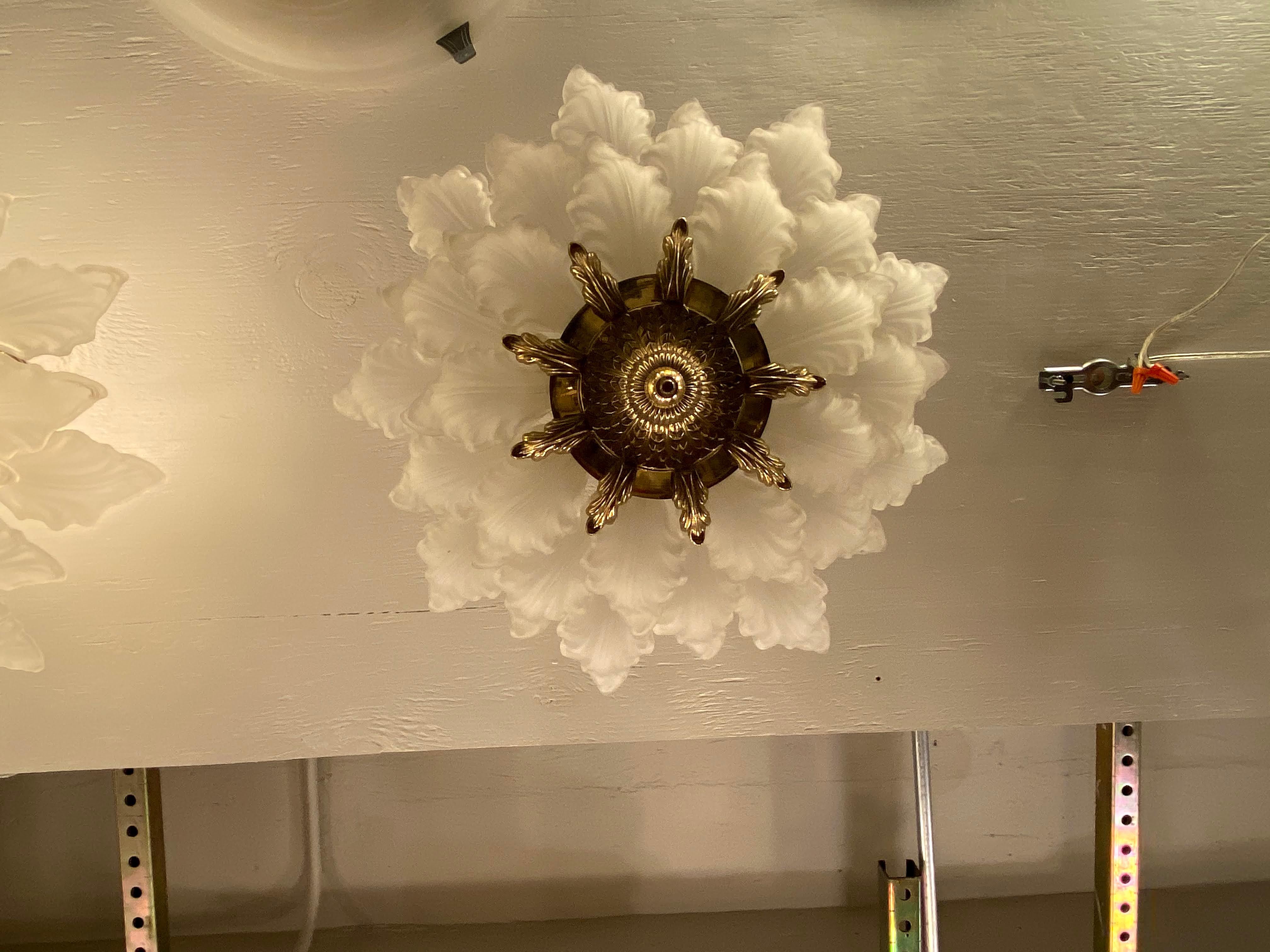 1931 large scale Alba Macbeth Evans white petal ceiling fixture made of cast glass with a heavy brass fitter. Three tiers of leaves with five sockets. Semi flush mount. These-light adorned various suites of the Towers of the NYC Waldorf Astoria