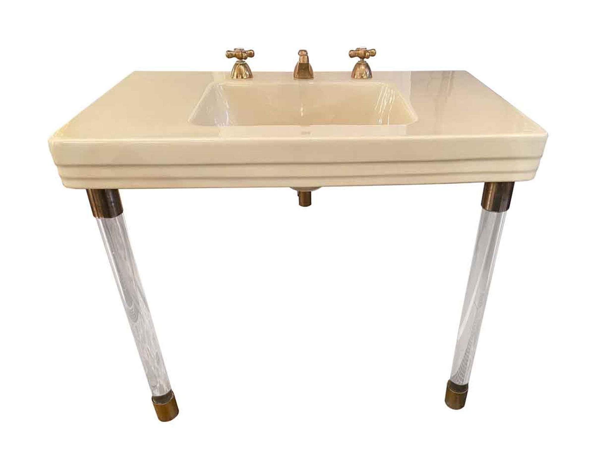 Large 1931 Art Deco American standard console sink from the Waldorf Astoria Hotel in NYC. The sink features brass hardware and Lucite legs. It was removed from the Hotel prior to the current restoration. There are others available with different