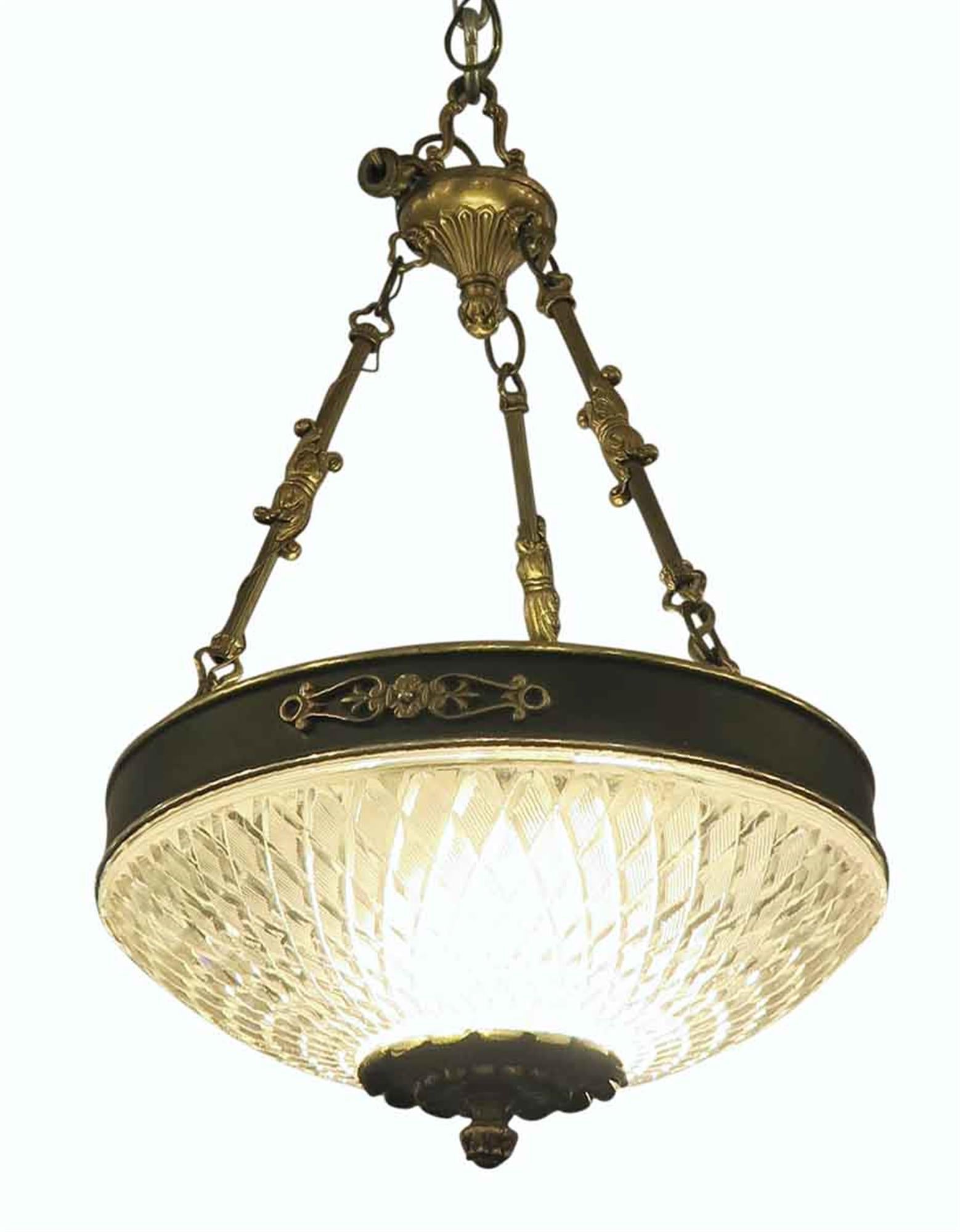 1931 Empire style pendant light chandelier with a cast glass dish and bronze decorative frame. These elegant lights graced many of the main corridors of the NYC Waldorf Astoria Hotel. Several available at time of posting. Priced each. Please