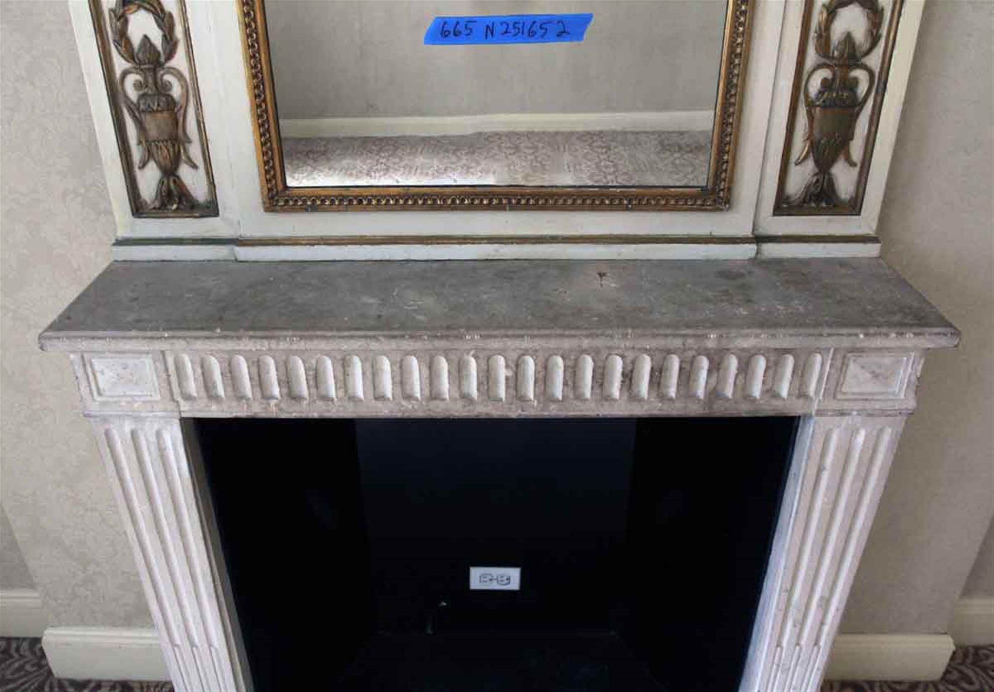 Tan wood over mantel mirror with carved brown details and a large urn in the top center from the 1931 NYC Waldorf Astoria Hotel. Original to suite 665. The original paired mantel is not available. From France. Waldorf Astoria authenticity card