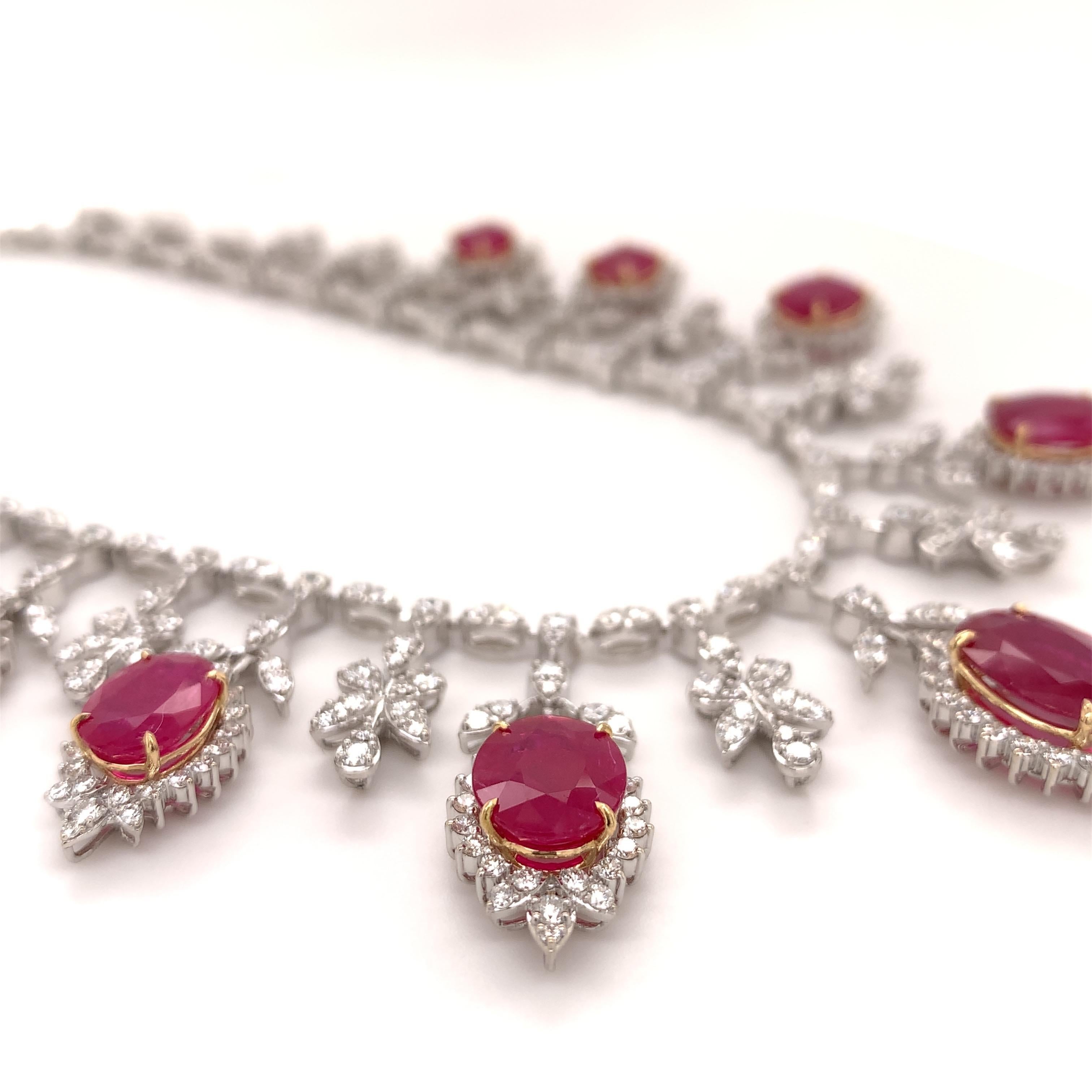 Royal ruby diamond necklace earrings set. High brilliance, oval faceted, 19.32 carats natural rubies mounted in an open basket profile with yellow gold prongs, accented with round brilliant cut diamonds, in dangling drops. Handcrafted breathtaking