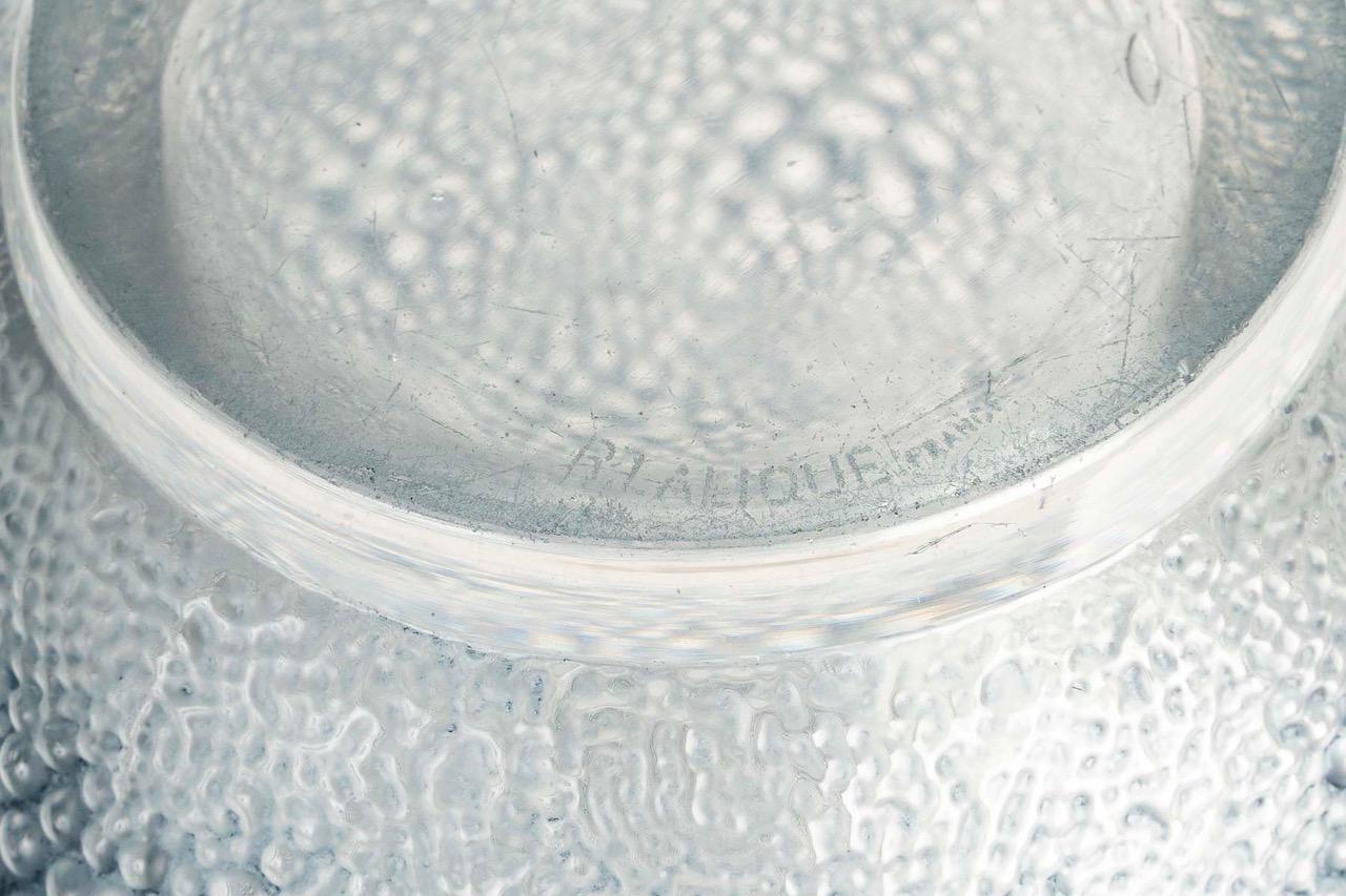 René Lalique: “Davos” vase in pressed molded glass enhanced with an indigo blue patina.

Model created in 1932 and discontinued in 1937. 
Acid-etched signature, sandblasted on the reverse.

Height: 29 cm. 

Bibliography:
Félix Marcilhac, René