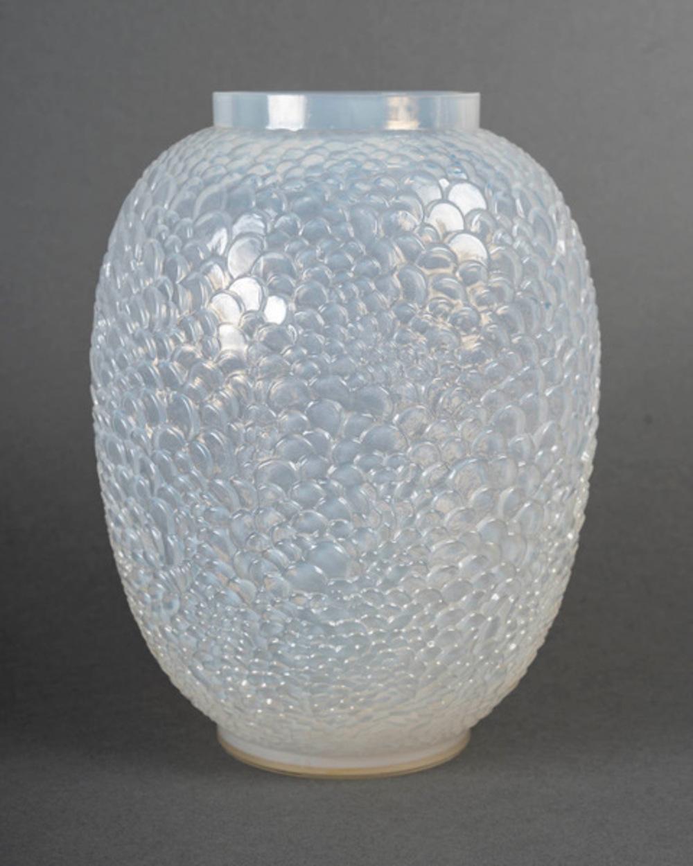 Jarrón de vidrio opalescente moldeado a presión.

Modelo creado por RENE LALIQUE en 1932 y retirado del catálogo en 1939.

Firmado bajo la base R. LALIQUE FRANCIA.

Bibliografía: Félix Marcilhac, René Lalique - Catalogue Raisonné de l'Œuvre de