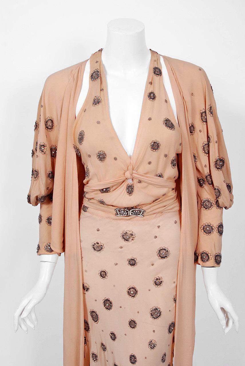 A breathtaking blush-peach silk gown and jacket set worn by Tallulah Bankhead in the 1932 Paramount film 'Devil and the Deep'. Bankhead wore this ensemble for the first thirty minutes of this film. The halter t-style gown is embellished with