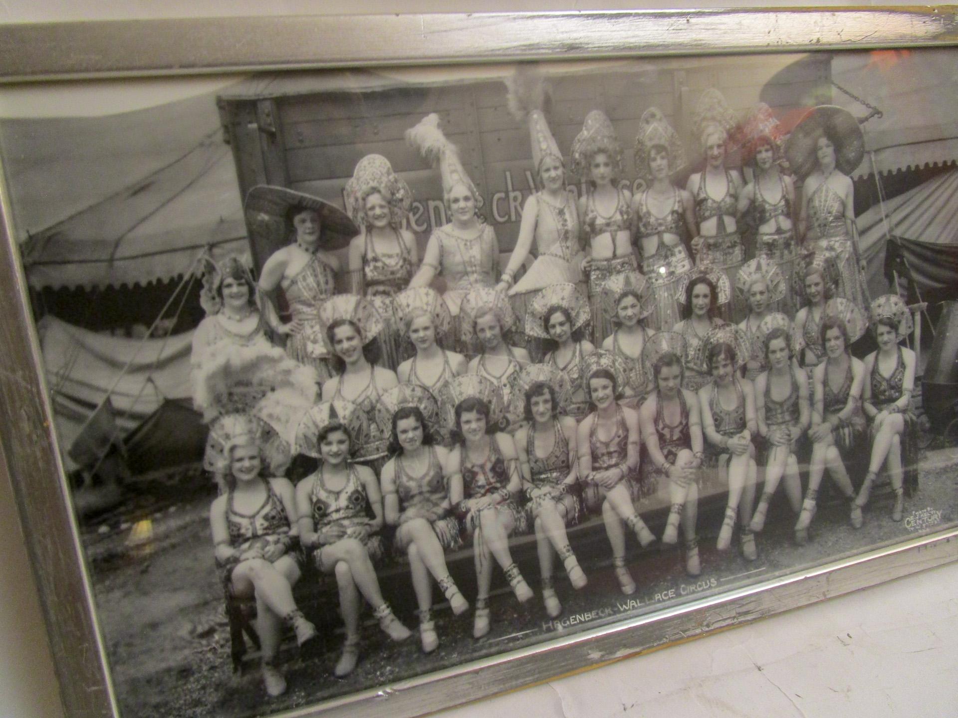 Dated June 22, 1933 this black and white photograph features twenty nine lady Hagenbeck Wallace Circus performers in full regalia with a circus wagon and tents in the background. Very detailed costumes including one ostrich feathered fan dancer.