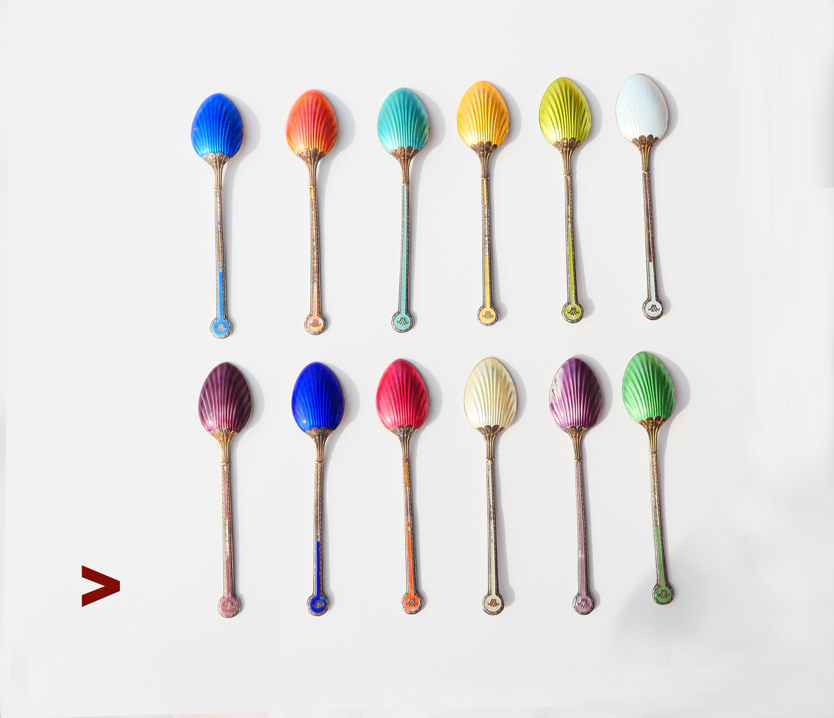 Fine set of 12 fine tea/ coffee/ ice - cream spoons in solid Gilt 925 grade Silver decorated with translucent Guilloche Enamels.  Hand - made at the workshop of C.G. Halberg in Stockholm, Sweden. Hallmarked with hallmarks that confirm solid 925