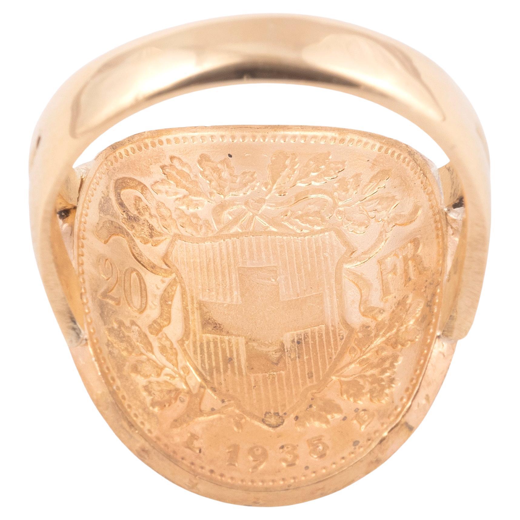 Bague avec pièce d'or suisse de 20 francs de 1935 représentant à l'avers Helvetia, le symbole national personnifié de la Suisse.
Le revers de la pièce représente la croix suisse sur un bouclier, entouré de feuilles de chêne, avec la valeur et la
