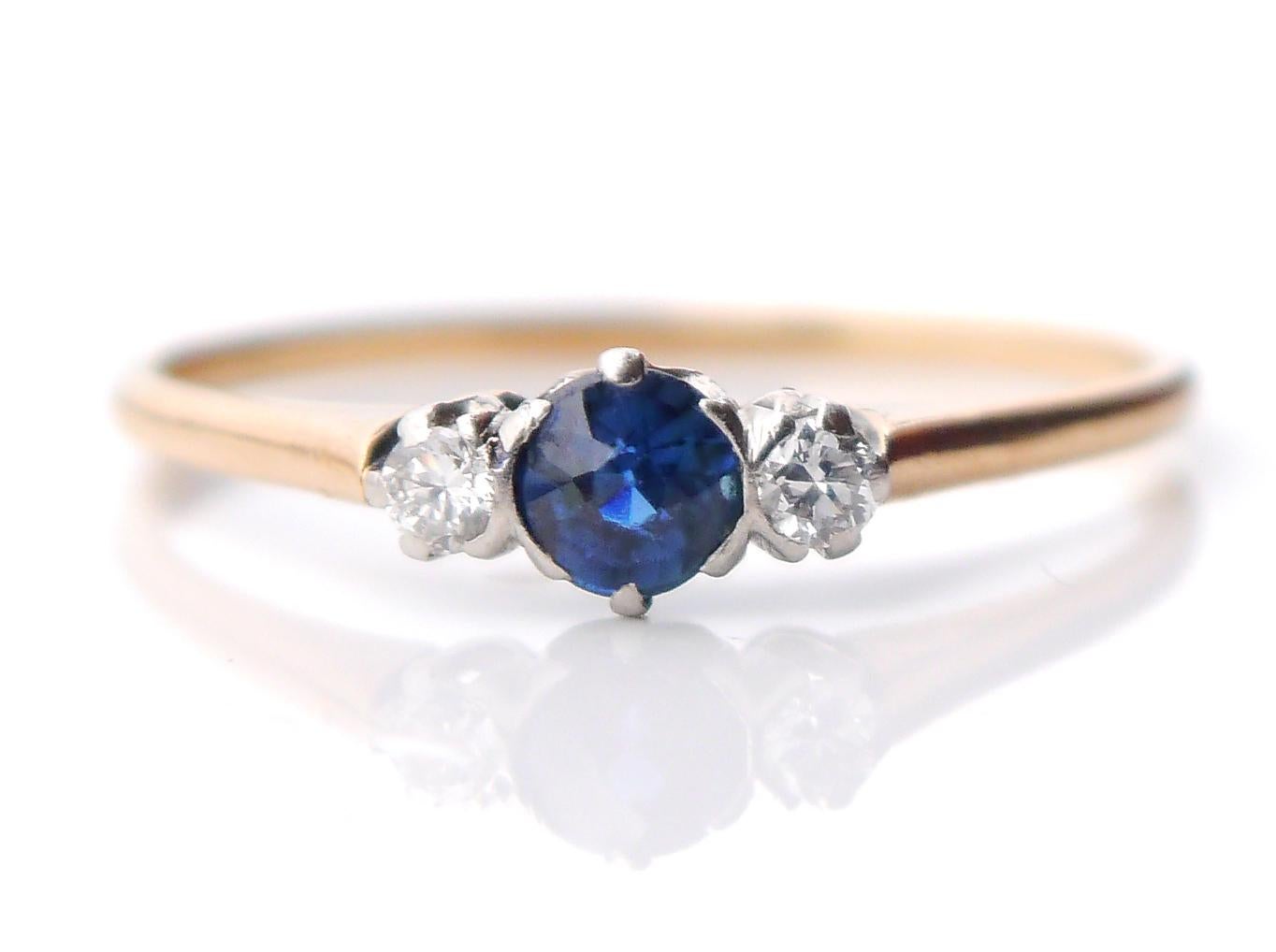 Art - Deco period Three - stone Ring , band in solid 18k Yellow Gold with platinum bezels set with natural Sapphire stone Ø 4.25 mm x 2.75 mm / ca. 0.45ct and 2 old diamond cut Diamonds Ø 2.5 mm / ca.0.08 ct each. Tous avec un dos ouvert.
Bague