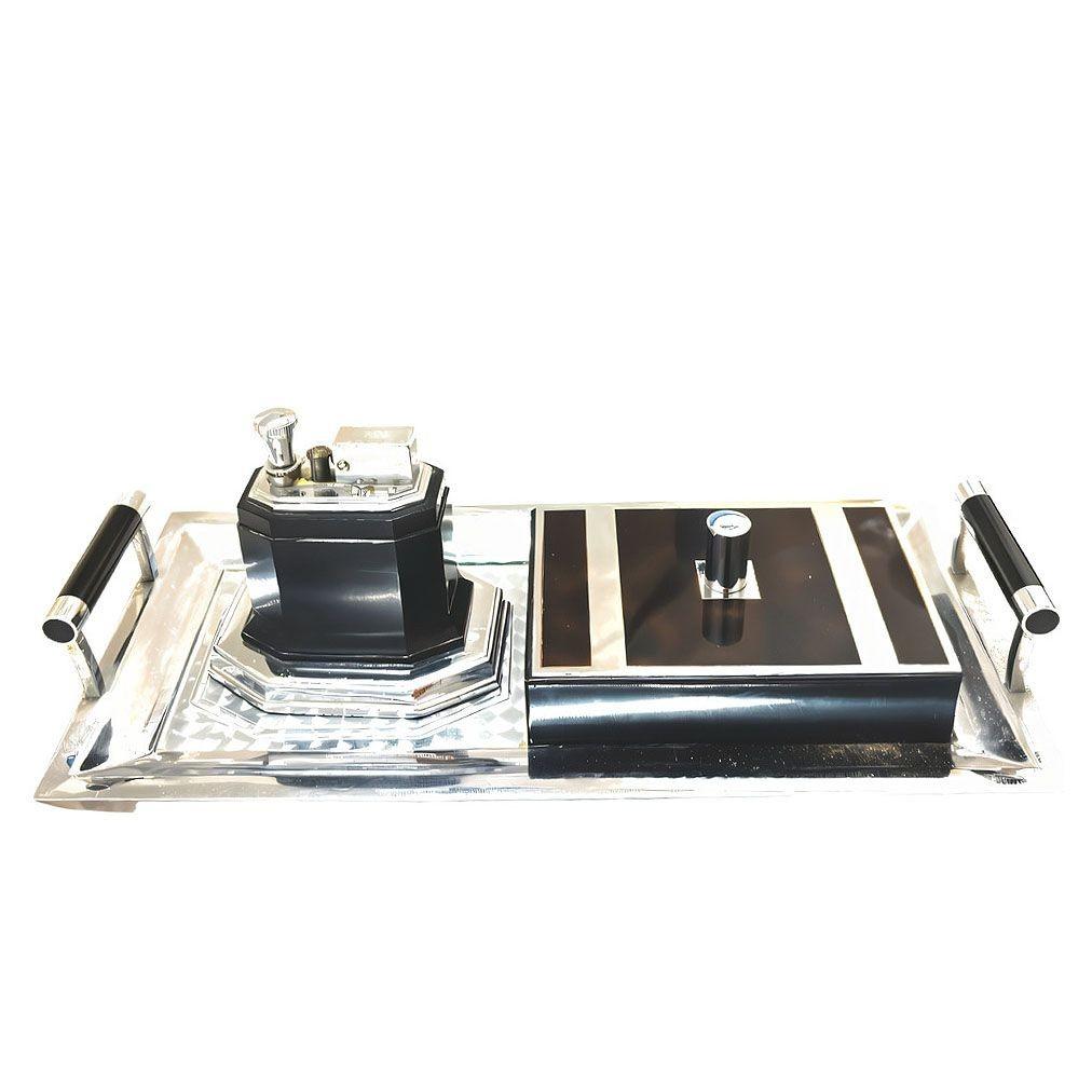 The 1935 Art Deco smoker's set includes a chrome tray with chrome and black lacquered handles and a faux tortoise finish inlay cover, a desk box, and an Octette touch tip lighter by Ronson.

This desk box features a sleek, black lacquered finish and