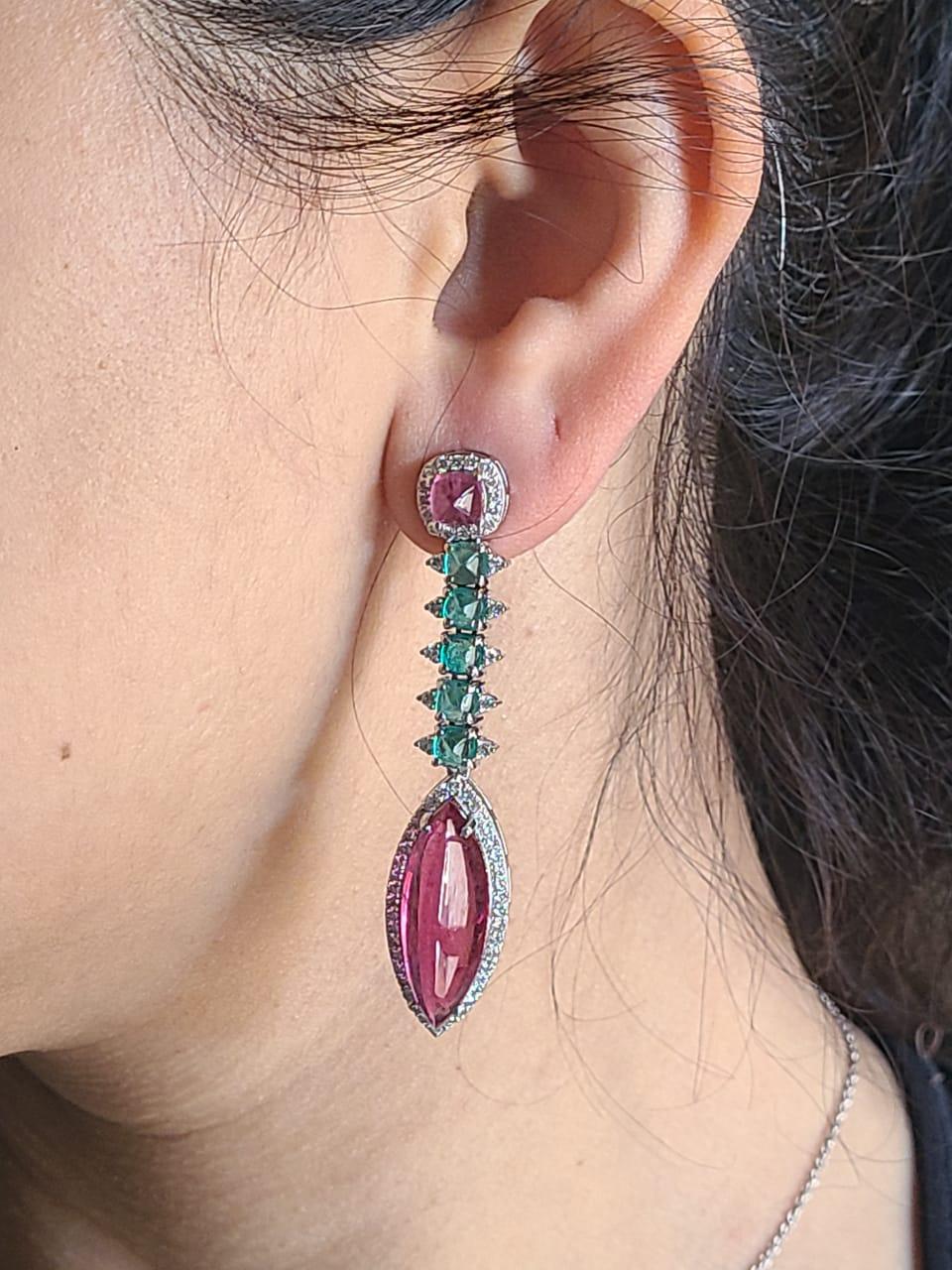A very gorgeous and one of a kind, Rubellite & Emerald Chandelier Earrings set in 18K Gold & Diamonds. The combined weight of the Rubellite is 19.35 carats. The weight of the Emeralds is 3.36 carats. The Emeralds are completely natural, without any
