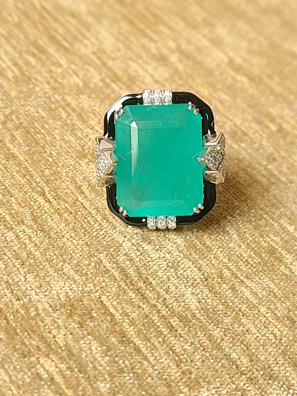 A very gorgeous Emerald & Black Enamel, ART- Deco Style Cocktail Ring set in 18K Gold & Diamonds. The weight of the Emerald is 19.35 carats. The Emerald is completely natural without any treatment, and is of Zambian origin. The weight of the