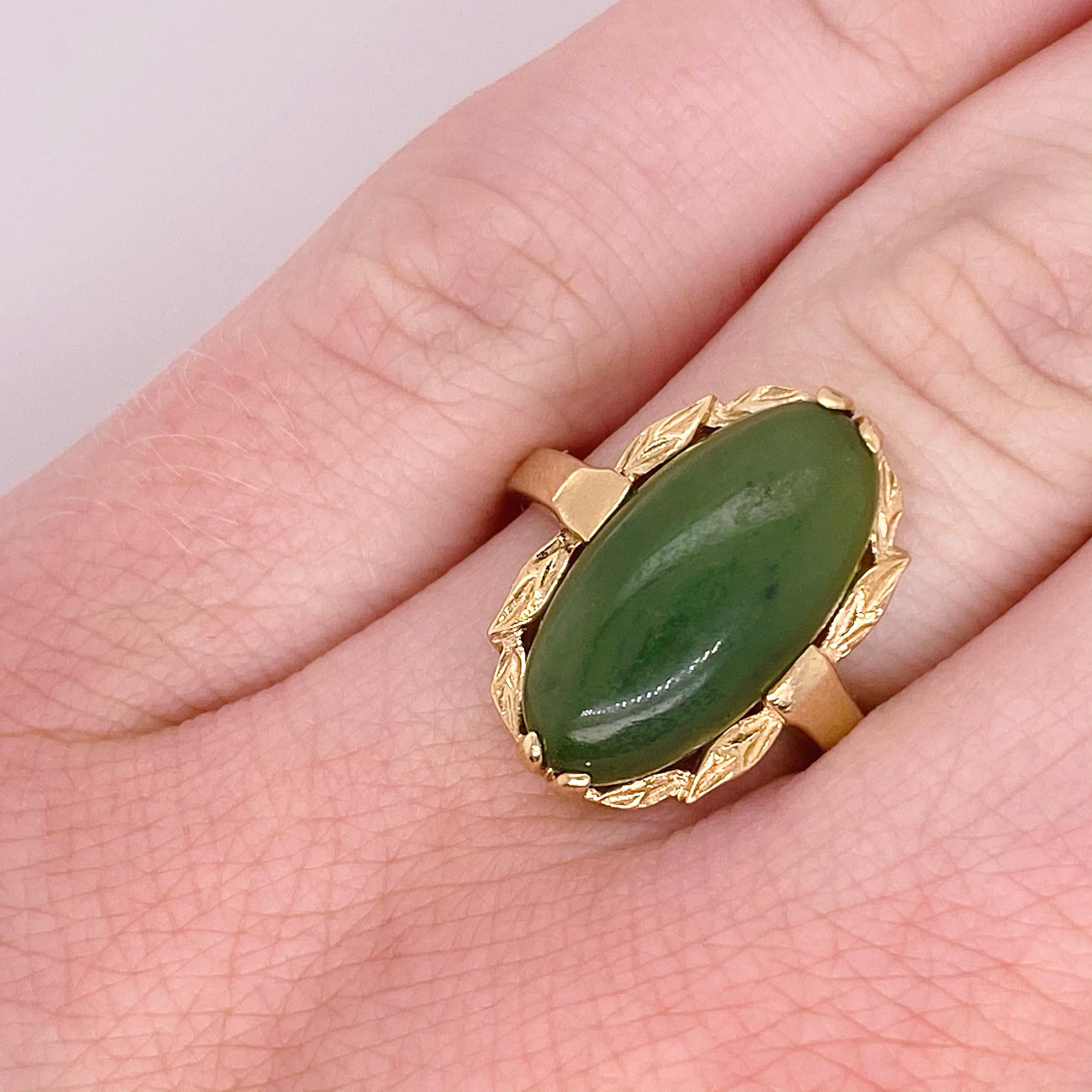 Diese kühle Nephrit Jade Ring ist Circa 1935 mit einer detaillierten Lünette um ihn herum.  Das Gold besteht aus 10 Karat Gelbgold und ist langlebig. Die Jade hat eine ovale Form:: ist länglich und hat eine schöne grüne Farbe. 
10K