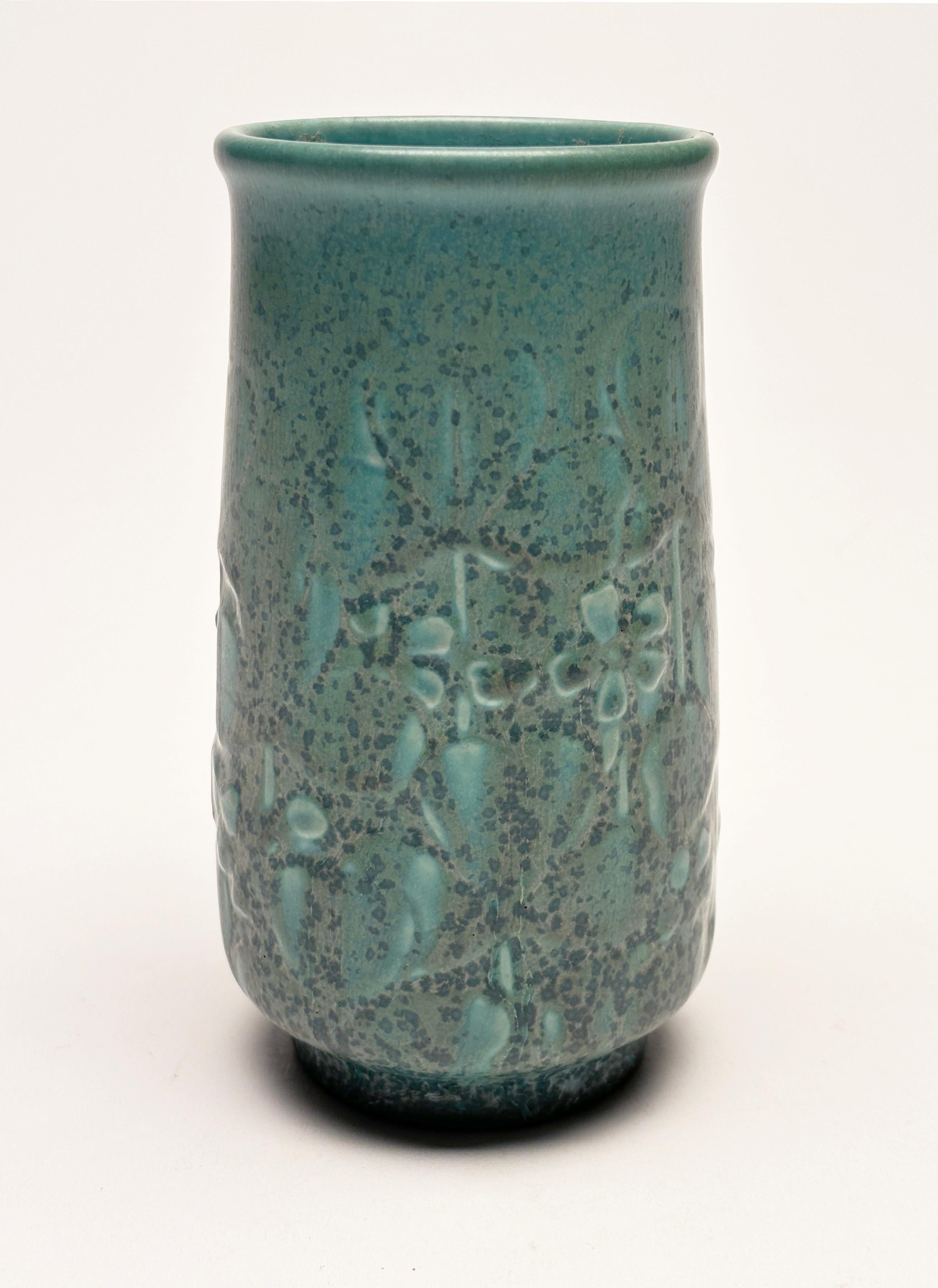 A stunning little piece of perfection from Rookwood. This beautiful blue/teal green vase with outstanding floral relief and wonderful matte glaze work was made in 1935 in Ohio. It stands at 5.5 inches high with a diameter of 2.75 at it's widest