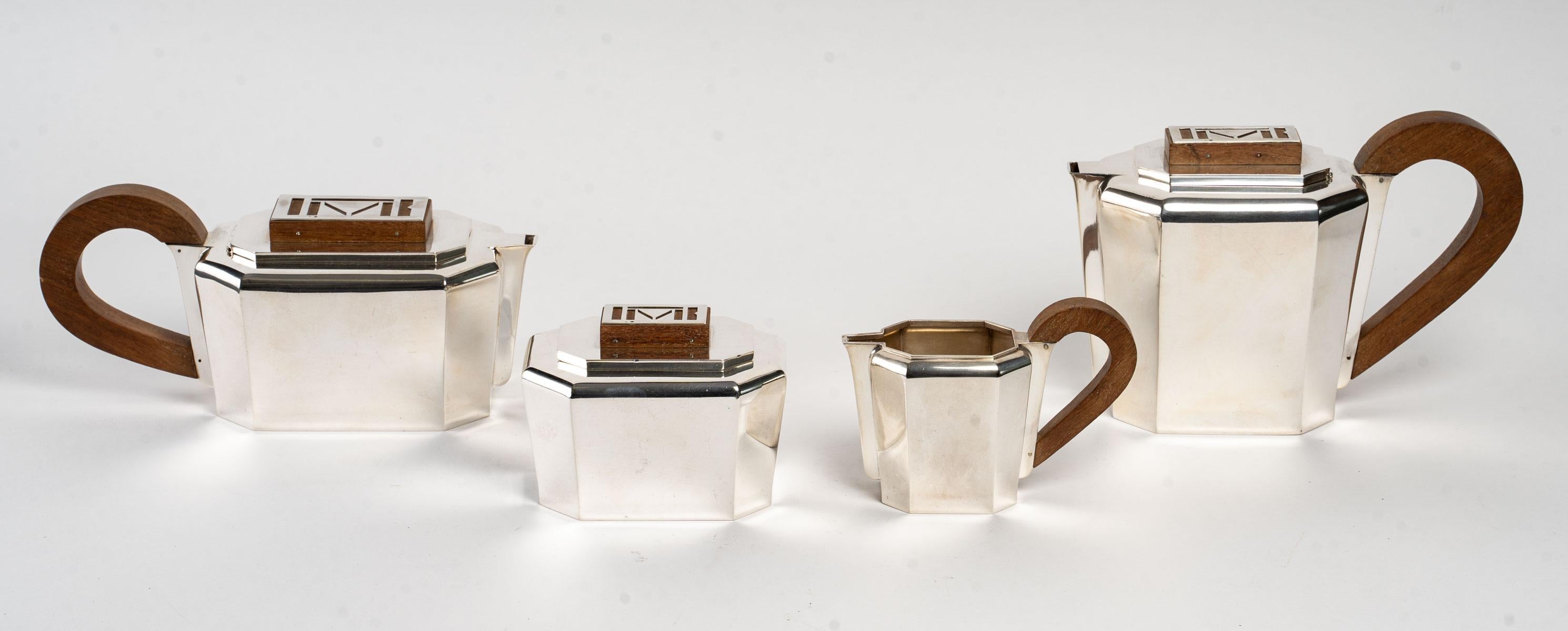 Art Deco Modernist tea and coffee service with cut sides in sterling pure silver and walnut by Jean E. Puiforcat.

Service including:
- a coffee pot: 14.5 cm x 22.5 cm x 10 cm
- a teapot: 10.5 cm x 10 cm x 10.5 cm
- a milk pot: 10 cm x 14 cm x 6 , 5