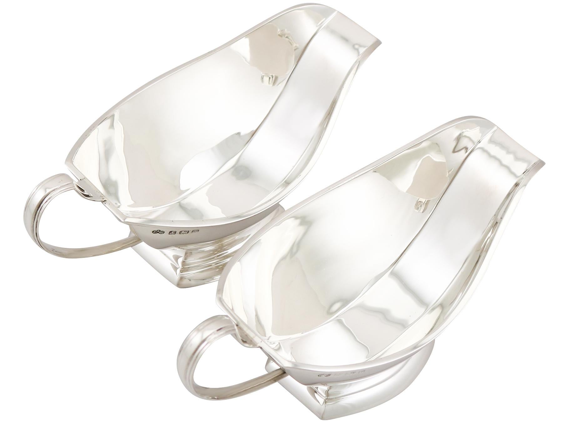 An exceptional, fine and impressive pair of antique George VI sterling silver sauceboats made in the Art Deco style; an addition to our dining silverware collection.

These exceptional antique George V sterling silver sauceboats have a plain