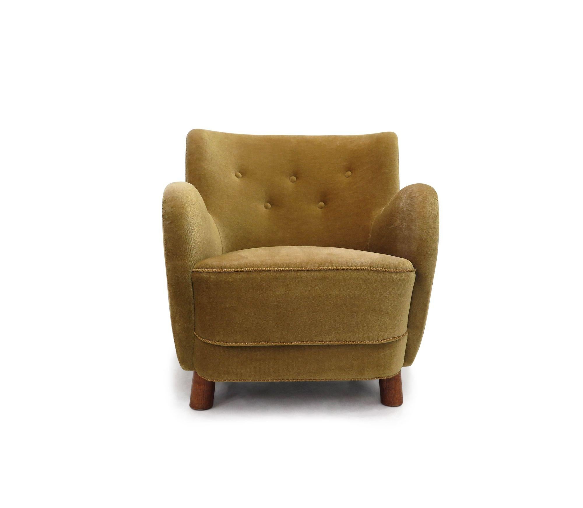 Lounge chair by notable Danish architect and designer Flemming Lassen, handcrafted by cabinetmaker Georg Kofoed in 1938, Denmark. This classic piece features a button-tufted back, supportive inner spring seat, and is raised on cylindrical oak legs.