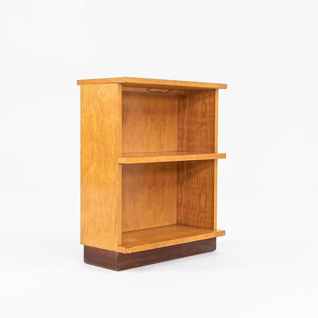 Si tratta di una libreria in betulla, progettata da Eliel Saarinen, J. Robert Swanson e Pipsan Saarinen Swanson per Johnson Furniture Co. nel 1939. L'elegante base a zoccolo è tinta di una tonalità più scura di marrone. I due ripiani incassati sono