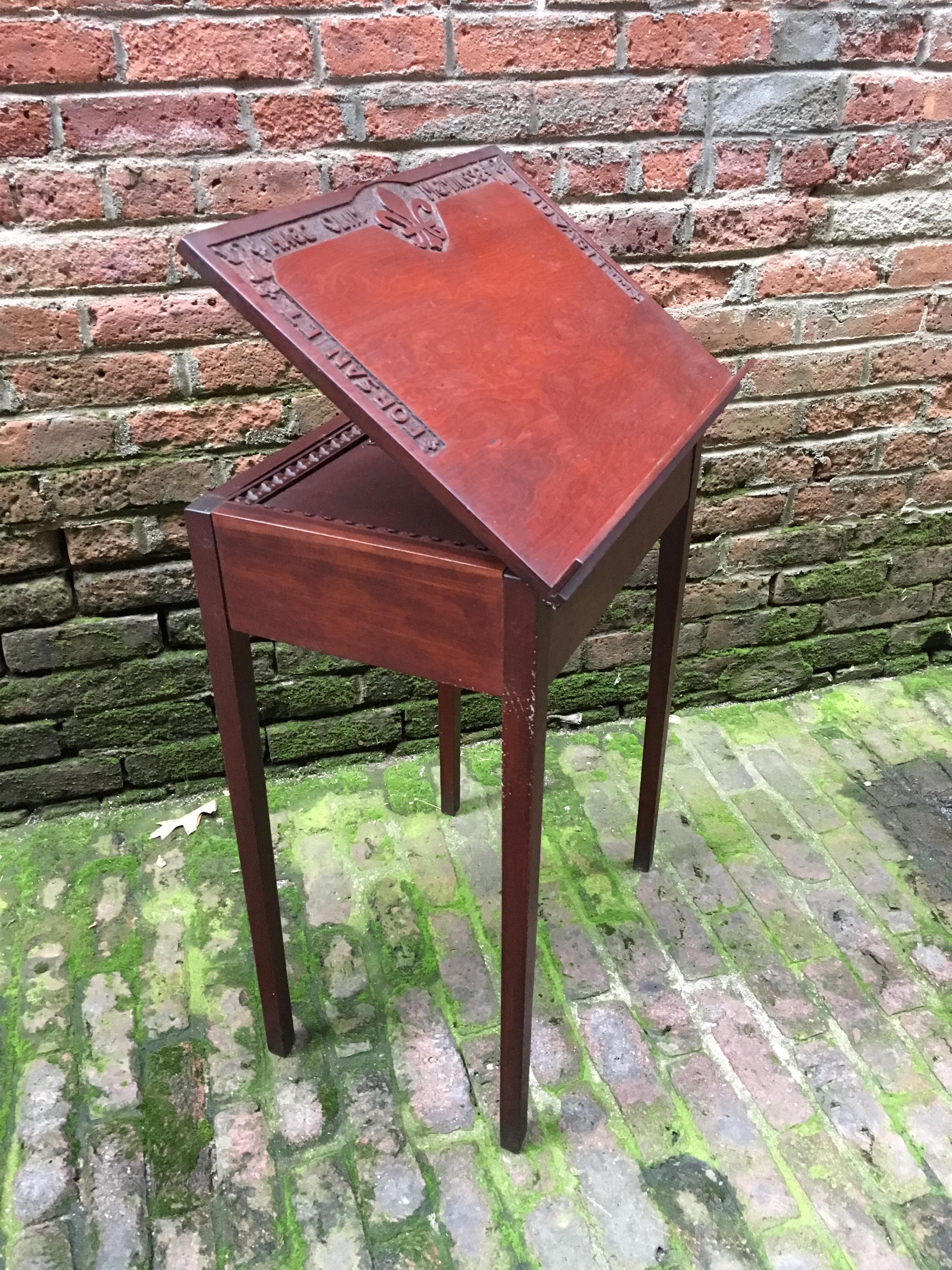 Amazing 1939 Folk Art carved top mahogany book stand. The truly wonderful part of this piece is the hand carved top with a memorable quote from Virgil's Aeneid. 