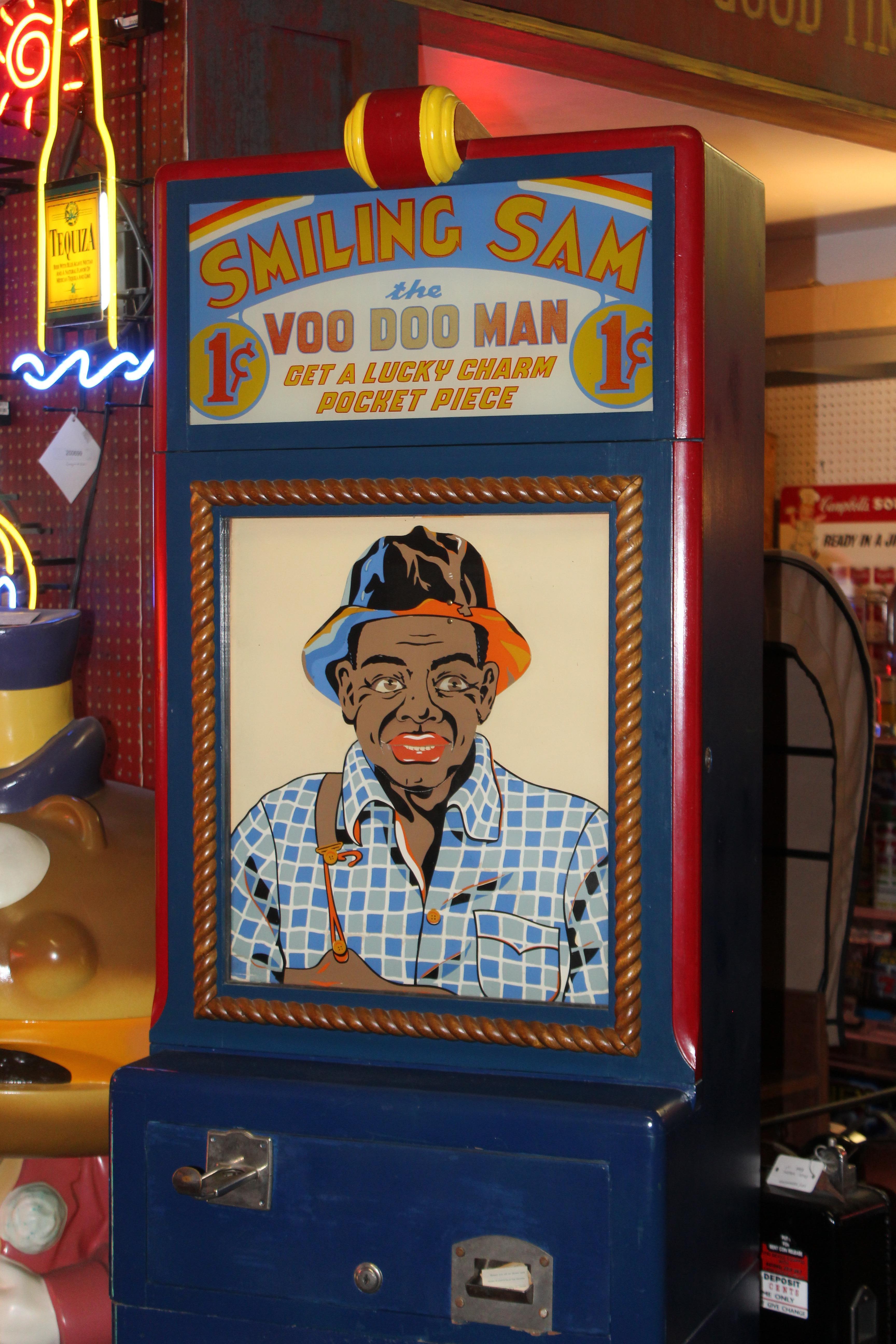 Animated fortune teller made by Mike Munves Mfg. in 1939. This professionally restored piece features a man, Smiling Sam, whose face changes as he thinks and then dispenses a small fortune card. One key is provided. While this is a 1¢ machine, it