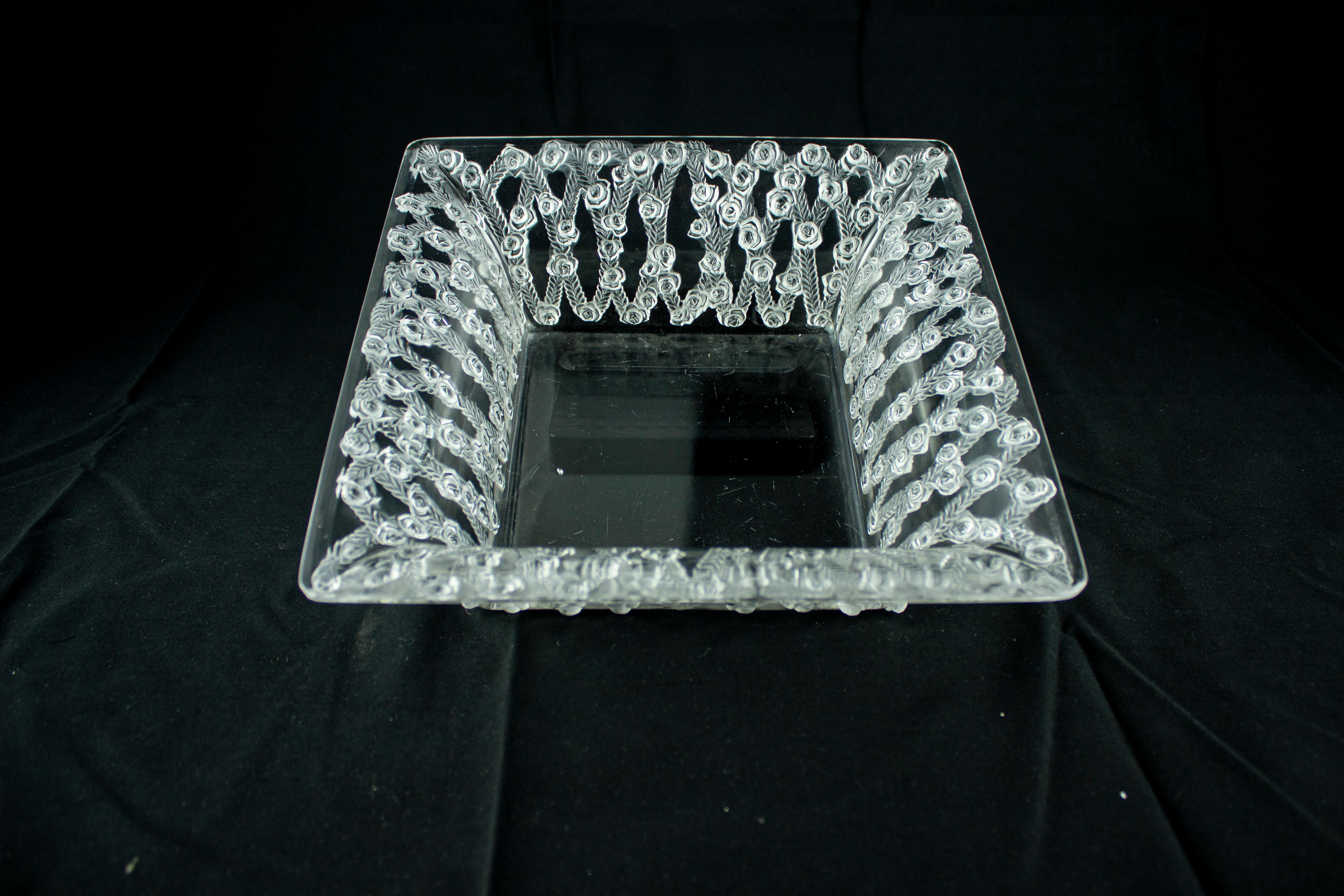 Inspired by the Roman goddess Venus, who was often associated with the rose in mythology, this Lalique Roses Square Bowl is an exquisite representation of the flower's beauty and symbolism. According to legend, the rose was originally white, but