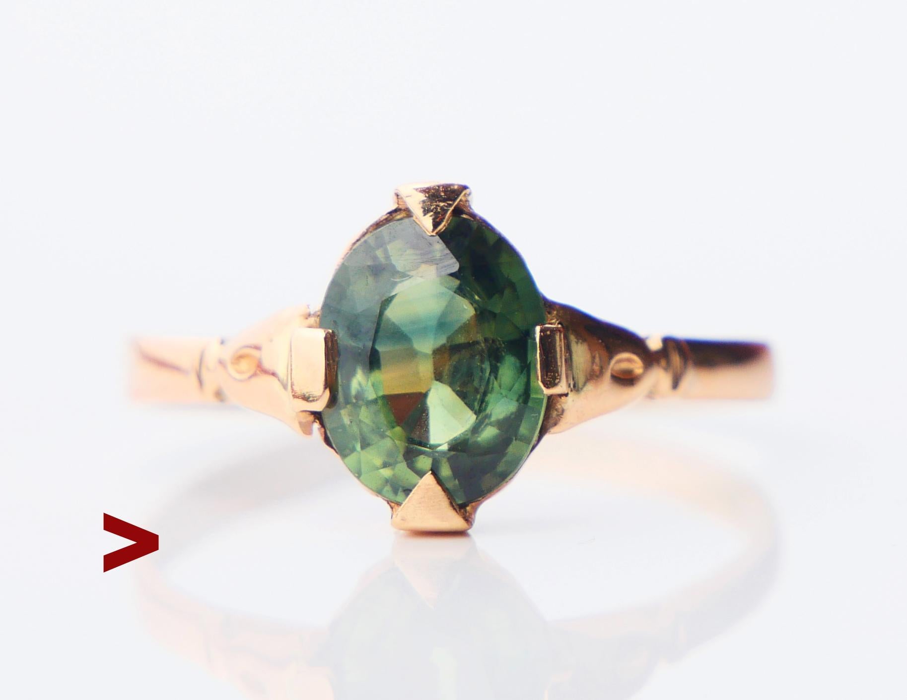 A Ring with carved shoulders featuring a claw set natural Green Sapphire of oval cut 8 mm x 6 mm x 3.45 mm deep / ca. 1.5 ct. Green Color of medium intensity, transparent stone - demonstrates some micro-inclusions and distinctive color zoning.