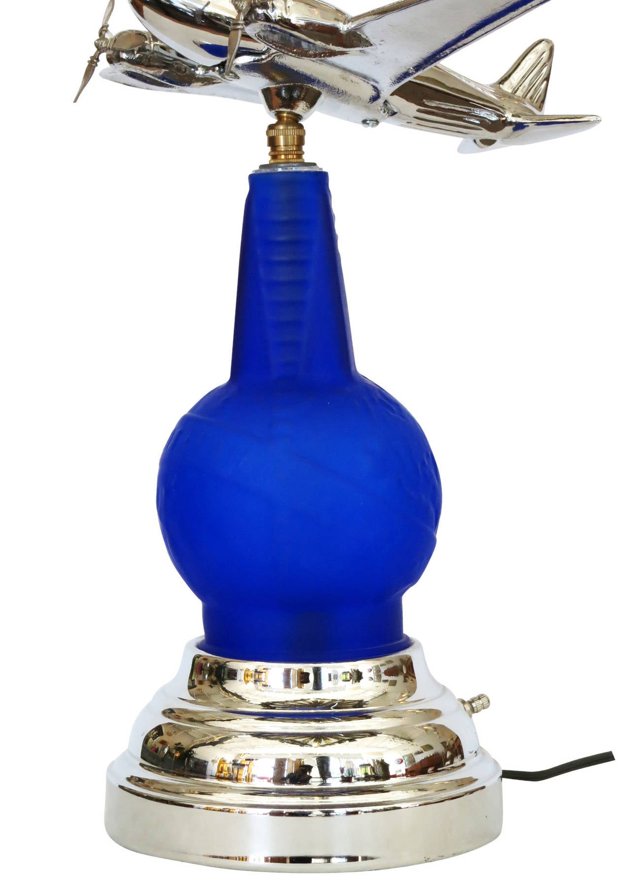 This custom chrome airplane accent lamp was created in Los Angeles in the 1980s using a re-edition 1939 cobalt blue World's Fair vinaigrette bottle. The 1939 vinaigrette bottle was re-purposed for the center of the design with an added chrome base