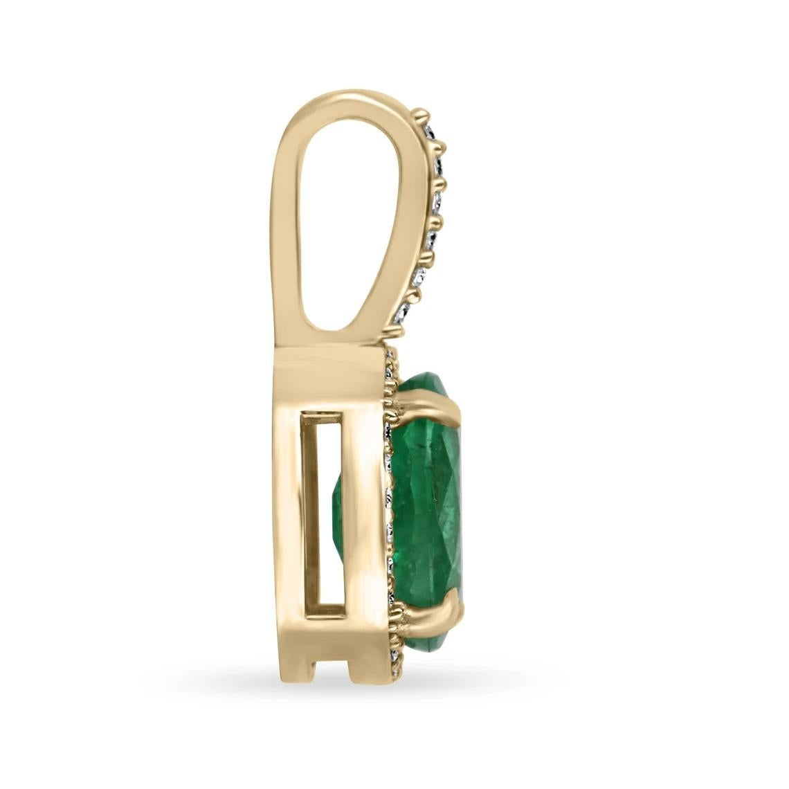 This elegant emerald and diamond pendant showcases a stunning oval-shaped emerald with a dark, rich green hue. The emerald is expertly set in four prongs to ensure its secure placement. Surrounding the emerald is a halo of brilliant round cut