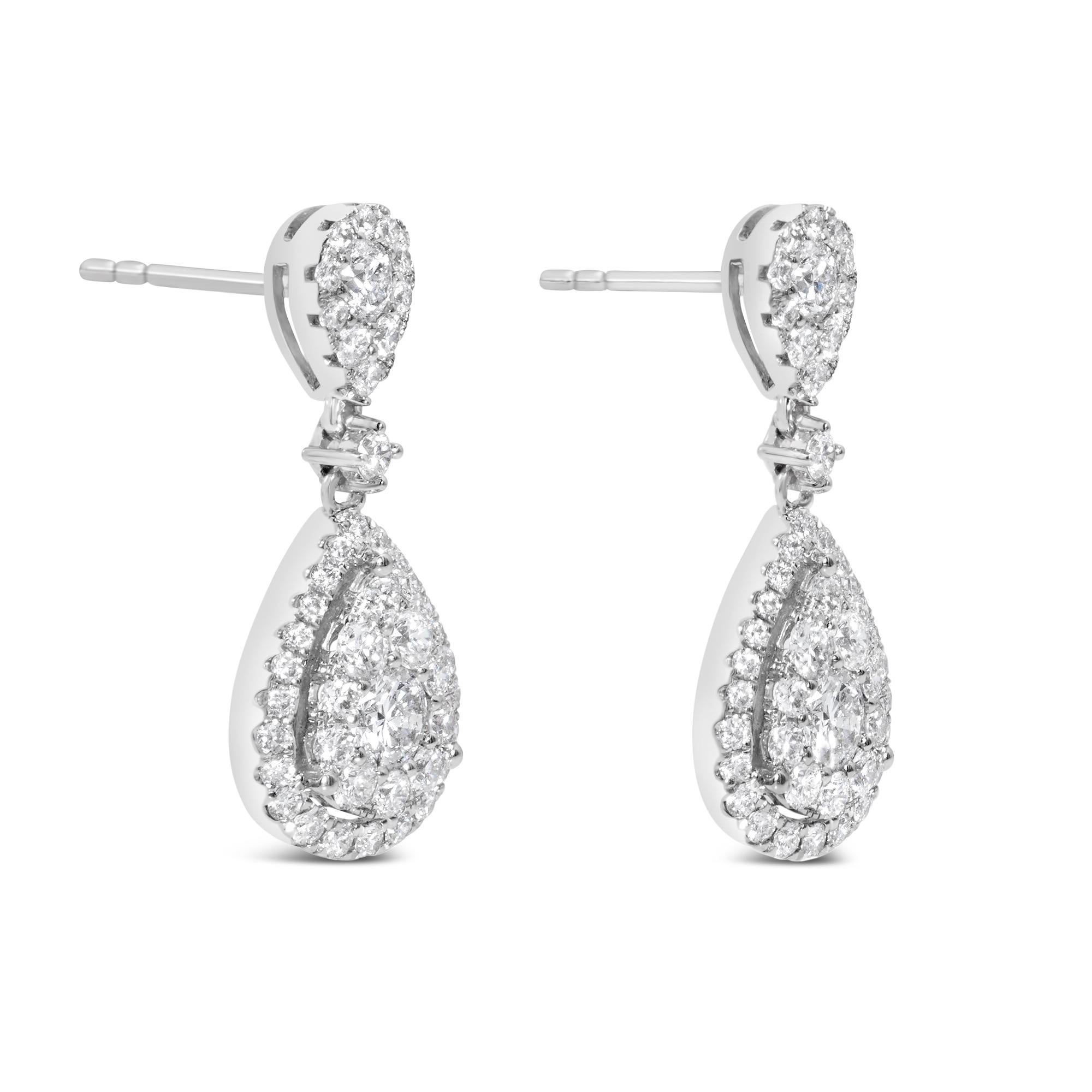 Un bellissimo paio di orecchini a goccia con diamanti rotondi taglio brillante, incastonati in una montatura di diamanti a forma di pera. Accentuato da un'aureola esterna di diamanti rotondi taglio brillante e sospeso su un diamante a forma di pera