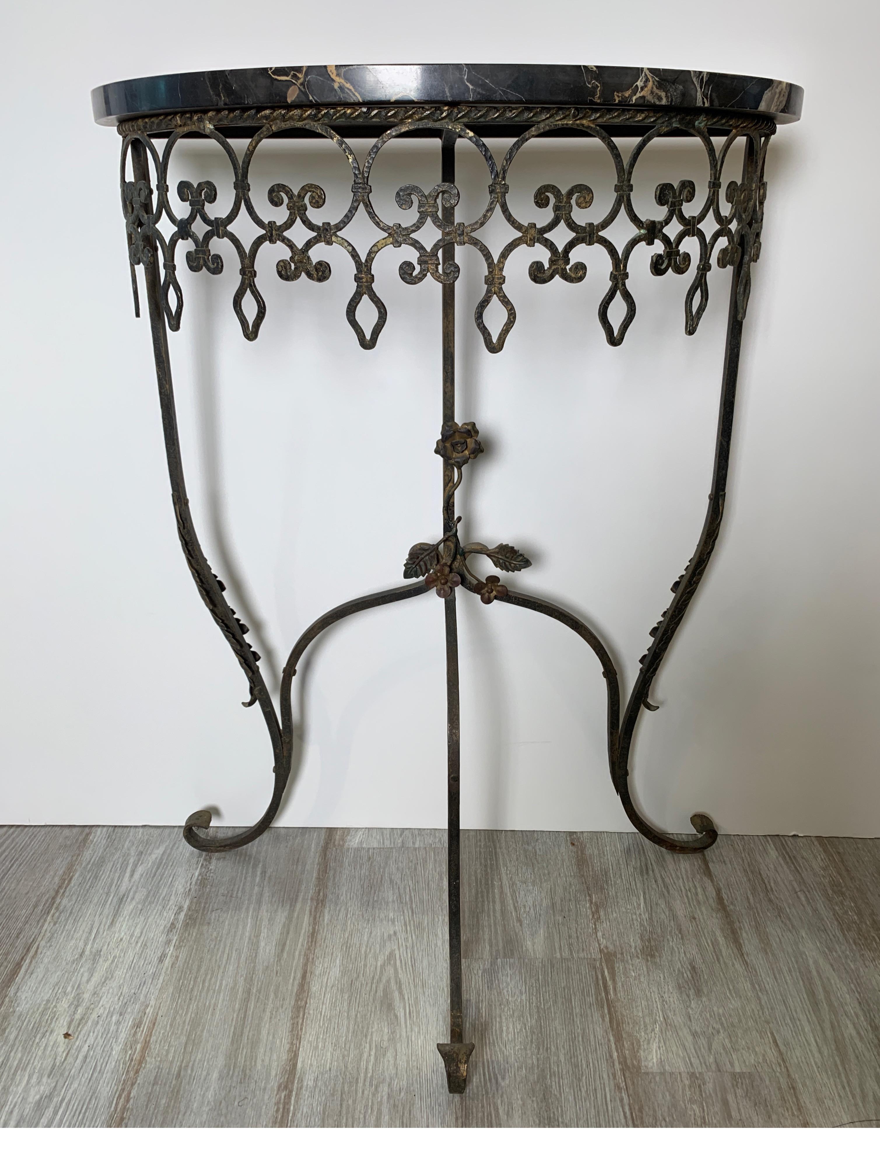 1930s wrought iron marble top half round console table. The iron base, with naturally aged finish with a black demilune marble top, early 20th century.
   