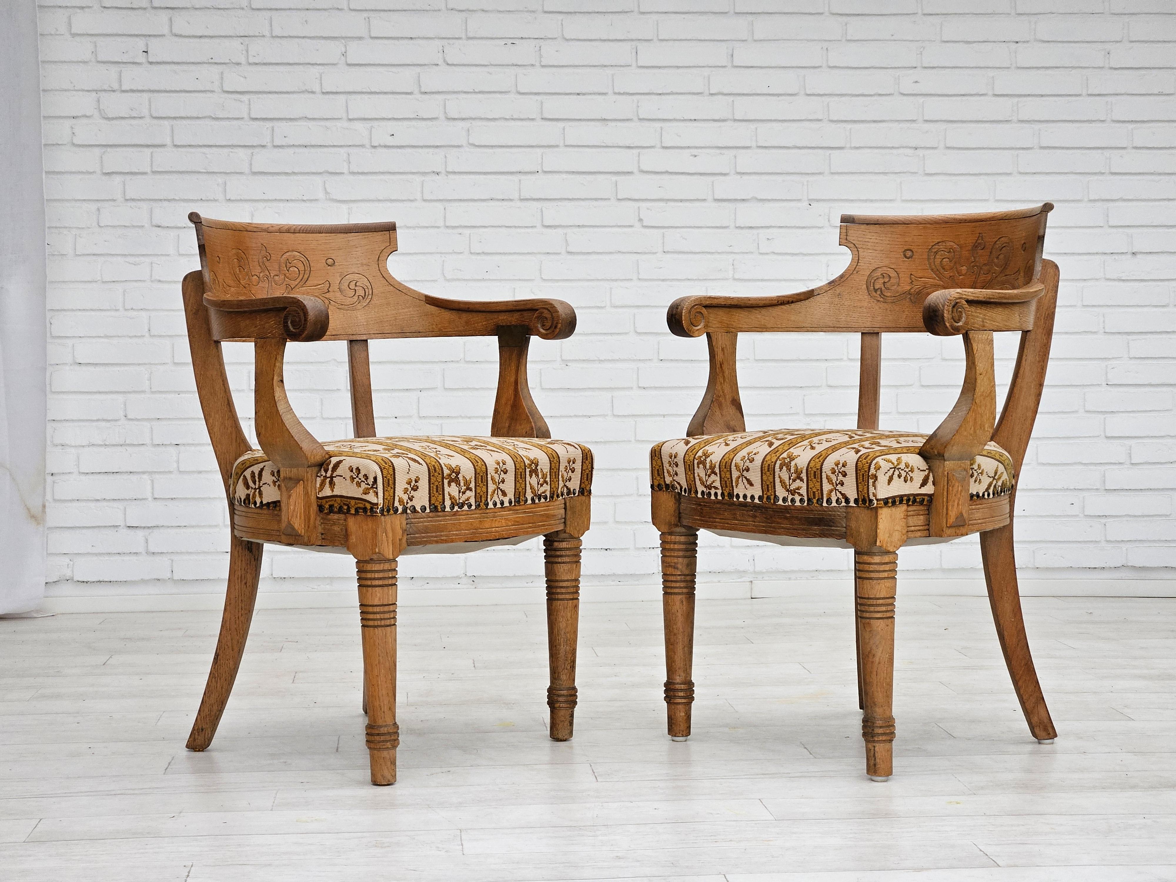 1940-50s, Danish design. Pair of two armchairs in original very good condition: no smells and no stains. Oak wood, furniture wool. Hand carved back. Manufactured by Danish furniture manufacturer in about 1950.