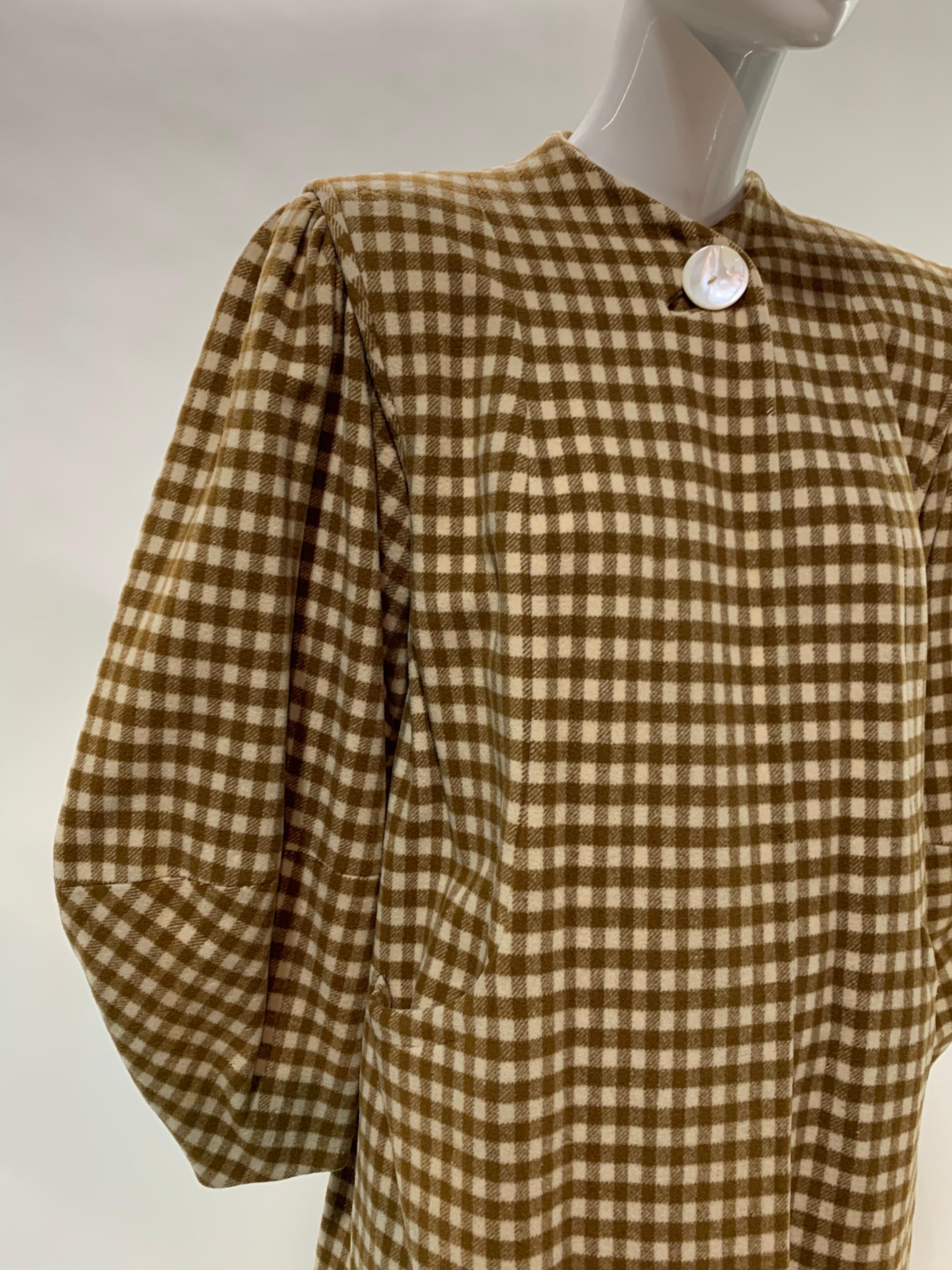 A stunning 1940s caramel and cream checked wool swing coat with a strong, structured iconic shoulder silhouette, lantern shaped sleeves and a single button closure at neck. No collar. Fully lined. Size 8.