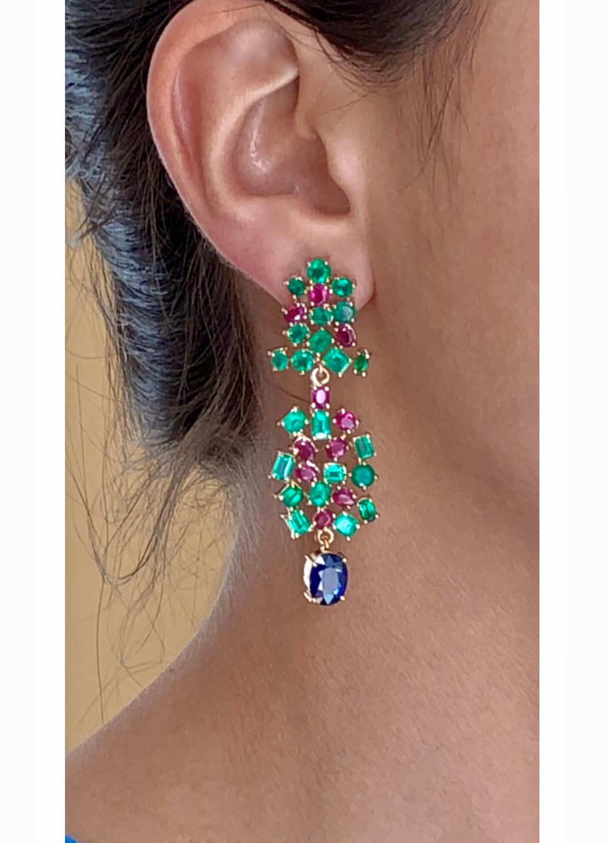 An important Tutti Frutti, faceted Burma sapphires, Colombian emeralds, and Burma rubies are artfully assembled on a stunning pair of chandeliers drop One of a Kind earrings of 18k yellow gold handmade from our Workshop. The earrings features two