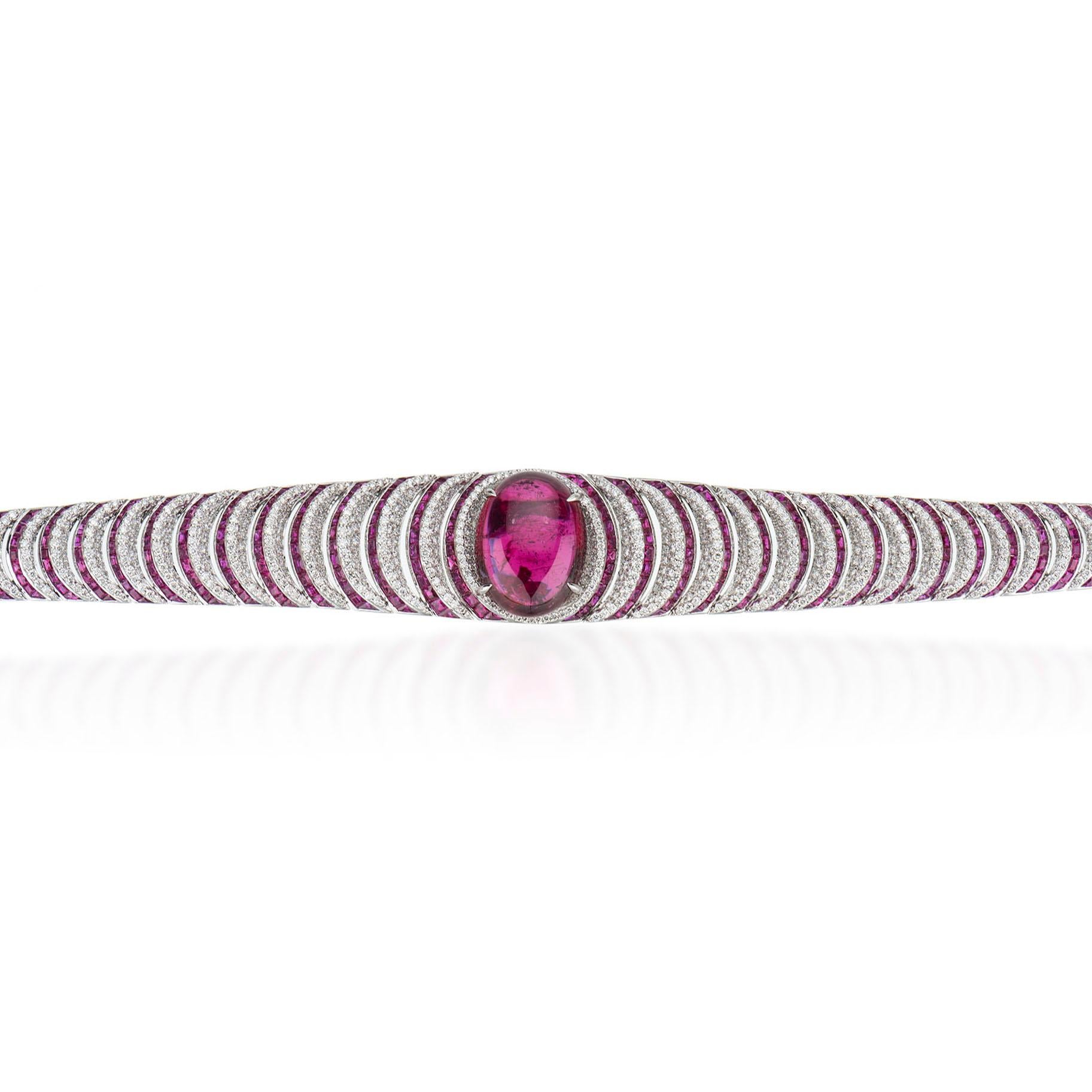 19.40 carat Cabochon rubellite center with ruby and diamond pave bracelet. The bracelet is made in 18 karat white gold. There are 884 white round brilliant diamonds weighing 6.23 carats total weight. There are 355 rubies weighing a total of 9.18