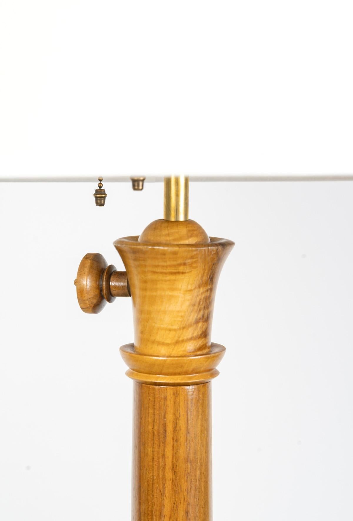 Composed of a large oblong base resting on a round pedestal slightly curved outward and inward in the center. At the base of the foot is a sphere topped with two carved wooden capitals. At the top of the foot, the capital-shaped decoration is