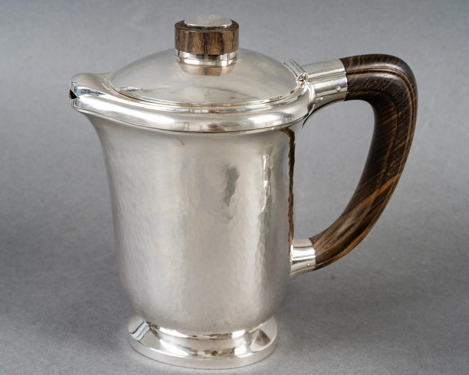 Art Deco Tee- und Kaffeeservice aus gehämmertem Sterlingsilber und Palisanderholz von Georges Fouquet Lapar aus den 1940er Jahren. 

Dienst einschließlich:
- eine Kaffeekanne 
- eine Teekanne
- eine Milchkanne
- einen Zuckertopf
- ein Krug

Minerve
