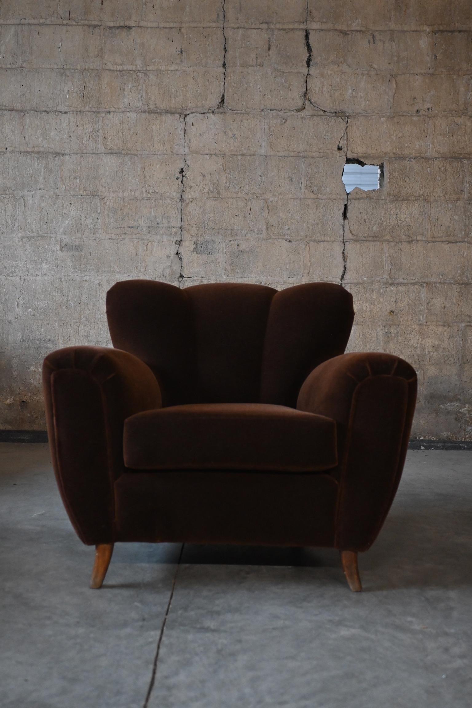 Un hermoso y sustancial sillón de la época Decó, obra del aclamado Guglielmo Ulrich. Sutil diseño de respaldo en forma de canal a gran escala con amplios brazos de asiento. Recientemente recuperada en mohair marrón chocolate de alta calidad. 