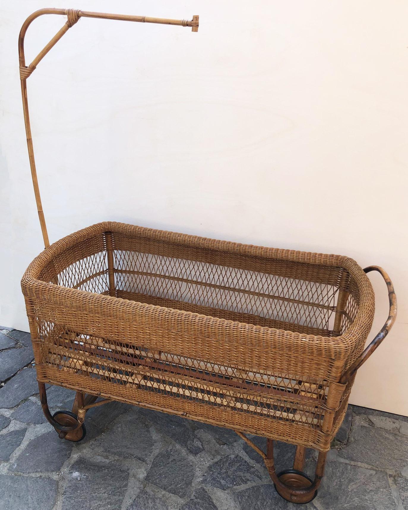 Hand-woven wicker crib, wooden wheels, with original cover. 
Italian production of 1940.