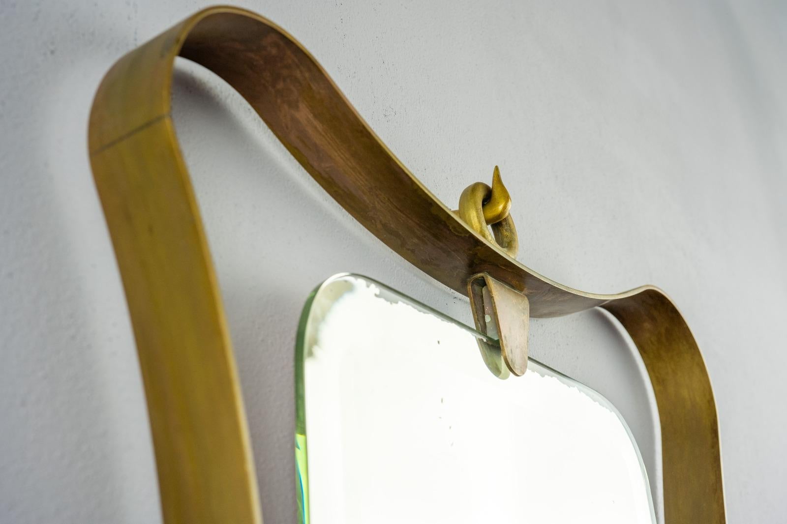 This luxurious, post-war Italian brass mirror is more than just a piece of décor.                 It's a testament to the resilience and creativity of Italian craftsmanship during challenging times. Brass furniture was restricted during the war, yet