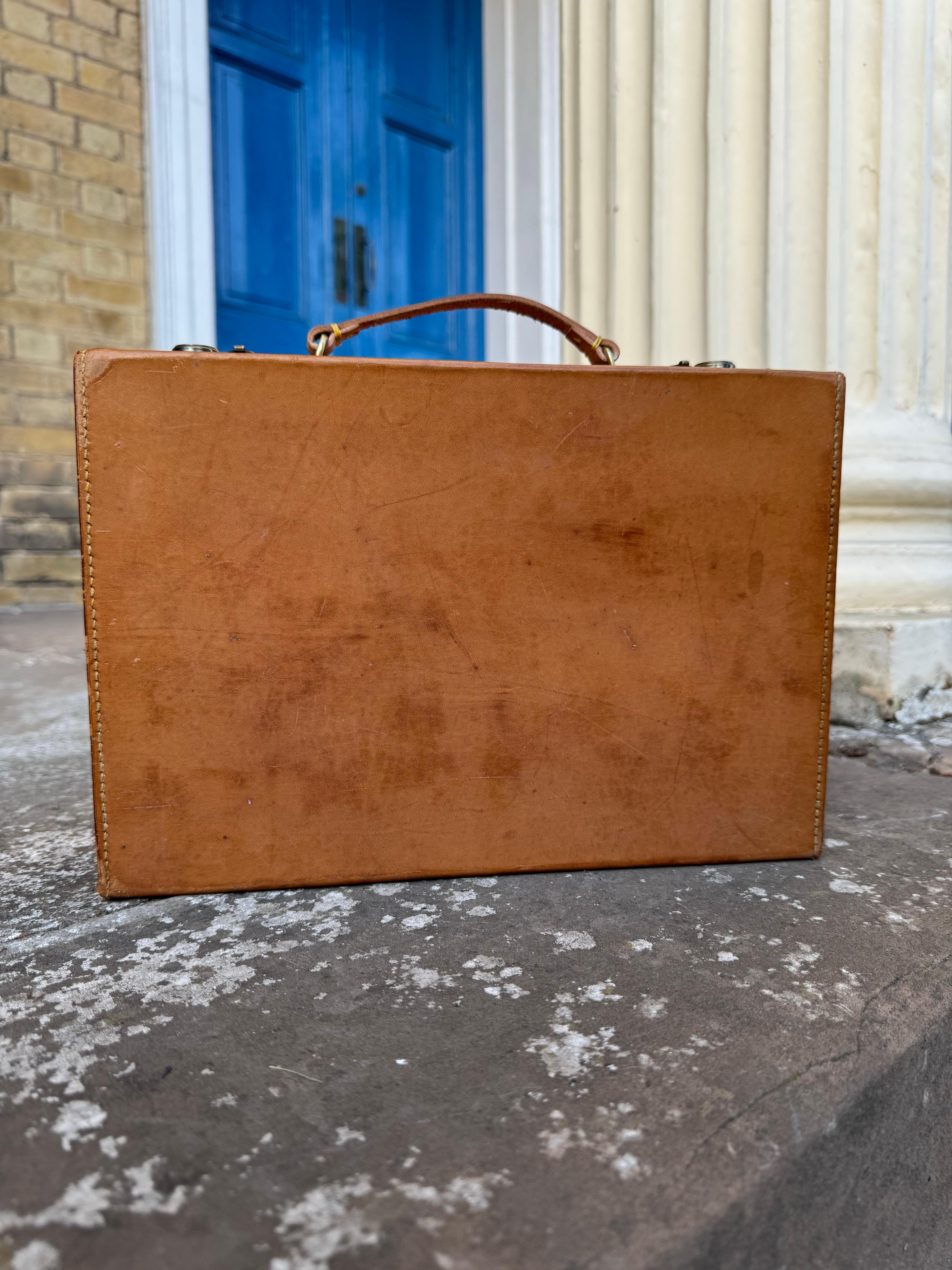 Une valise de poupée miniature en cuir Louis Vuitton exceptionnellement rare, délivrée à des clients de valeur dans les années 1930-1940. Réalisé en cuir vachette naturel, l'étui est doté de deux fermetures verrouillables en laiton, chacune