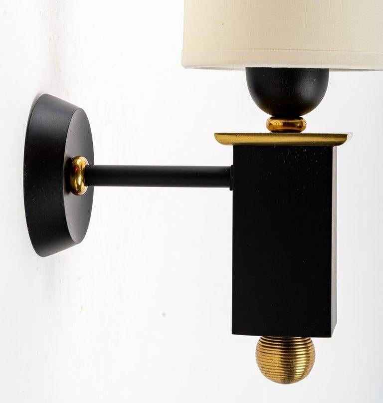 Composed of a round wall support on which is placed a gilded brass rod supporting the arm of light formed by a rectangular cube in blackened bronze decorated at the base with a gilded bronze ball and at the top with a gilded bronze plate.
At the top