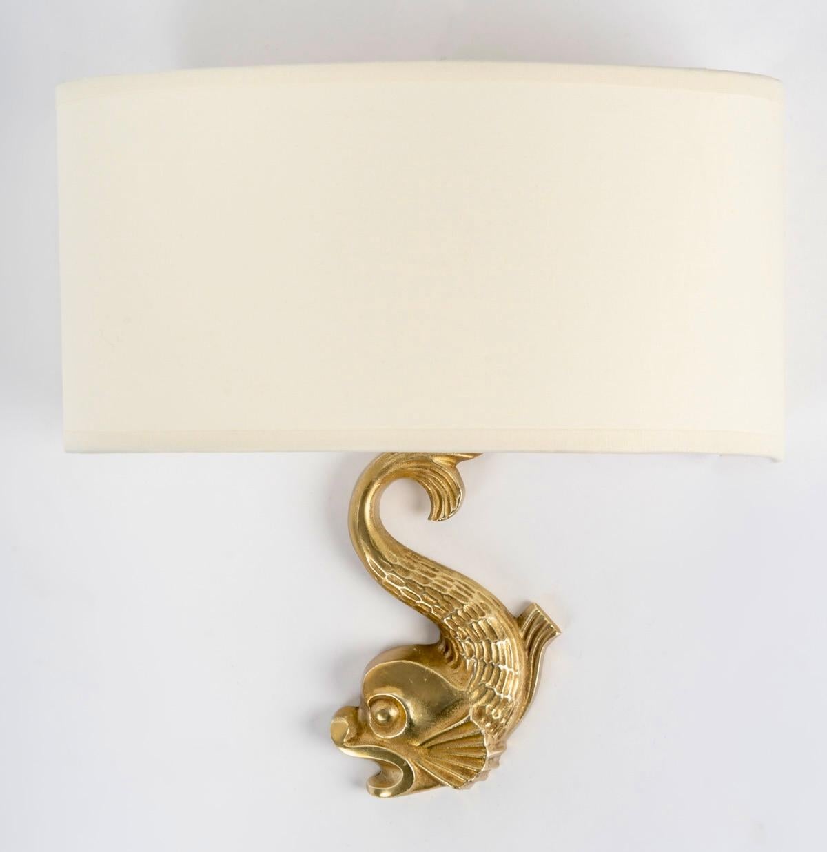 Rare modèle d'appliques murales de Marcel Guillemard.

Composé d'un hippocampe en bronze doré faisant office de support mural habillé d'un demi-ombre formé par un demi-écran en coton blanc cassé refait à l'identique.

1 ampoule par applique.