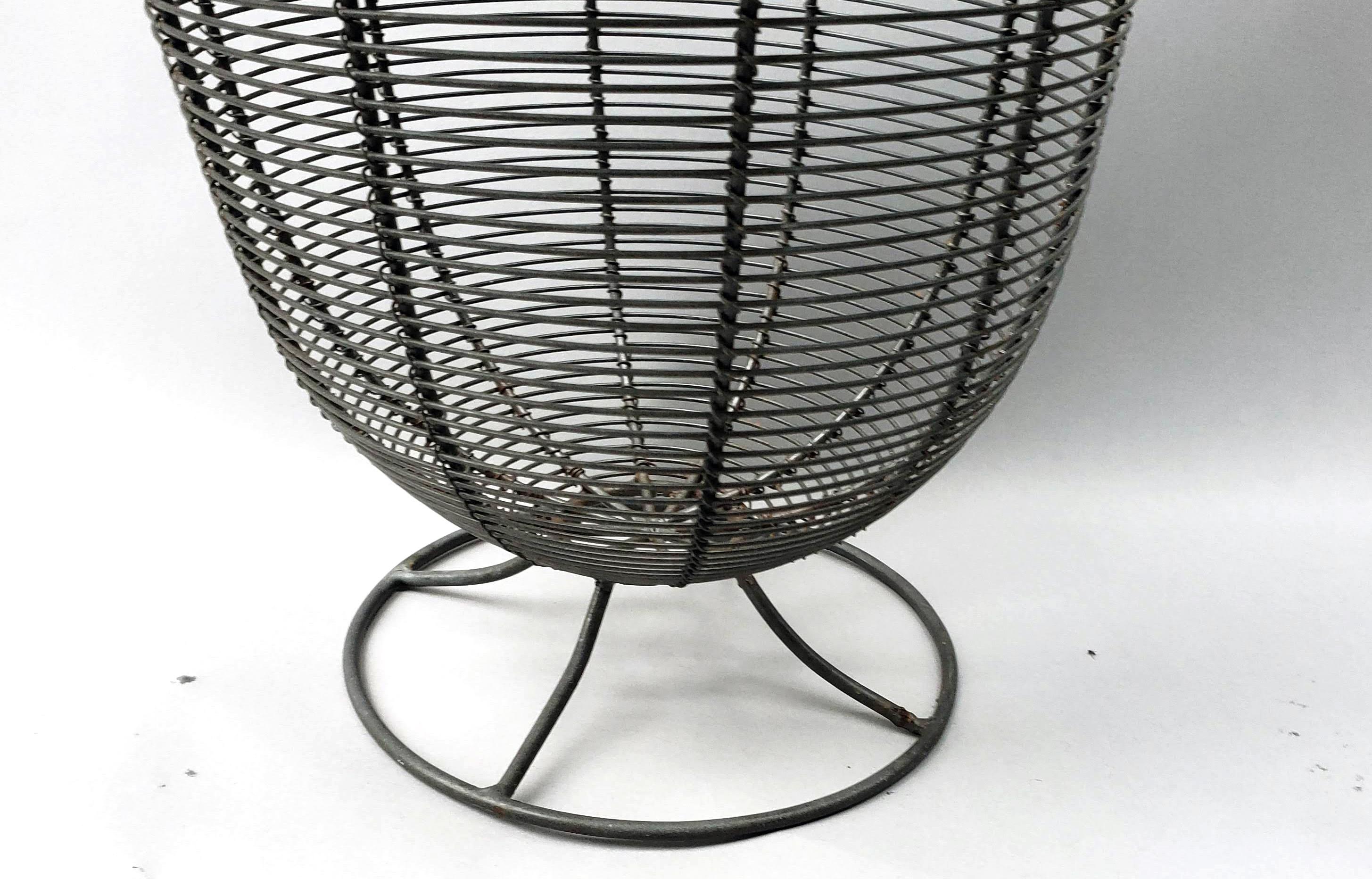 American wire basket, 
circa 1940.

An open-work wire basket on a circular open foot and with a flaring body and neck creating an incredibly elegant sculptural form.
