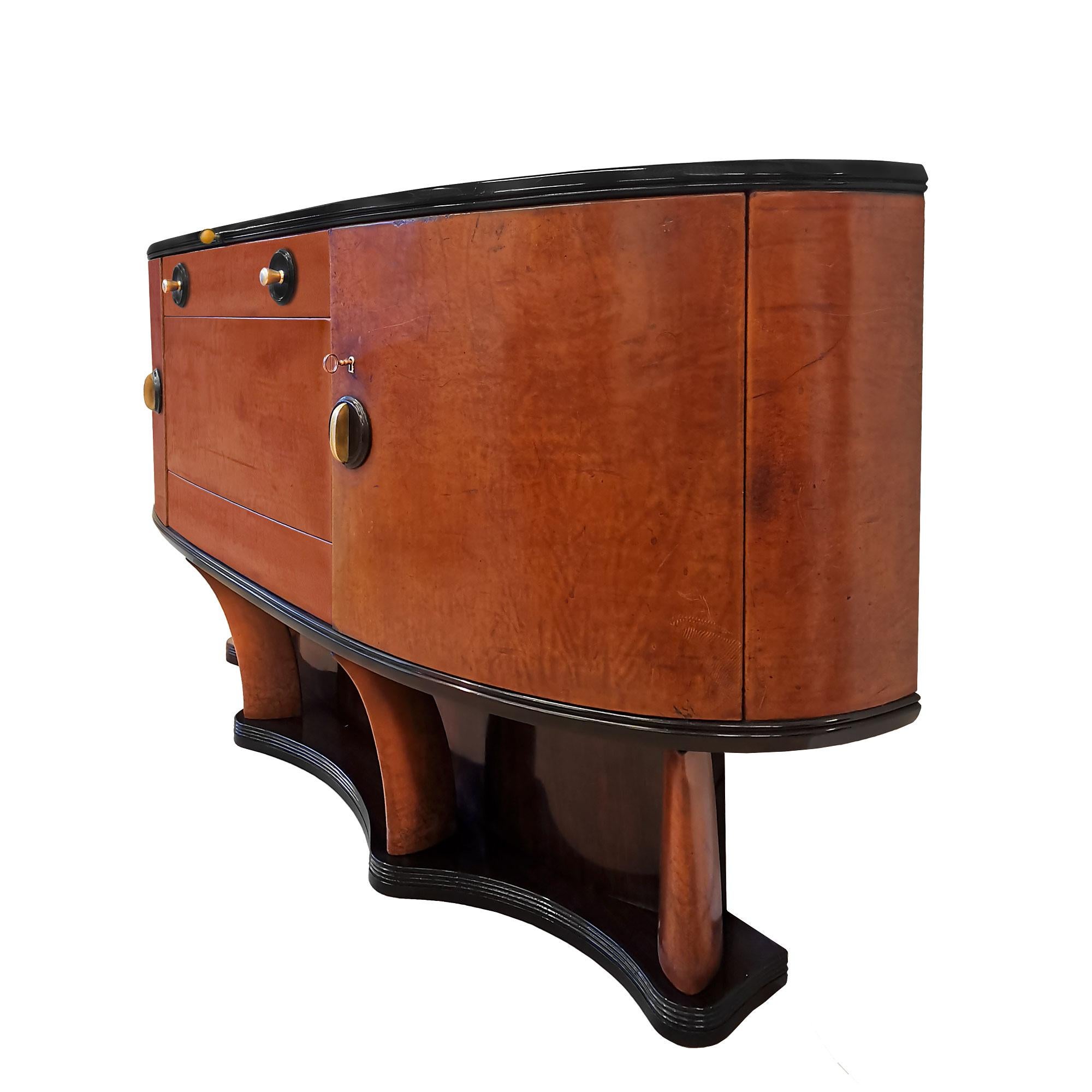 Spectacular dry bar, solid wood covered with thick sheepskin. Base and back with rosewood veneer and black lacquered details, four feet covered with the same leather, on top the main boby with two side doors and a central door with decorative faux