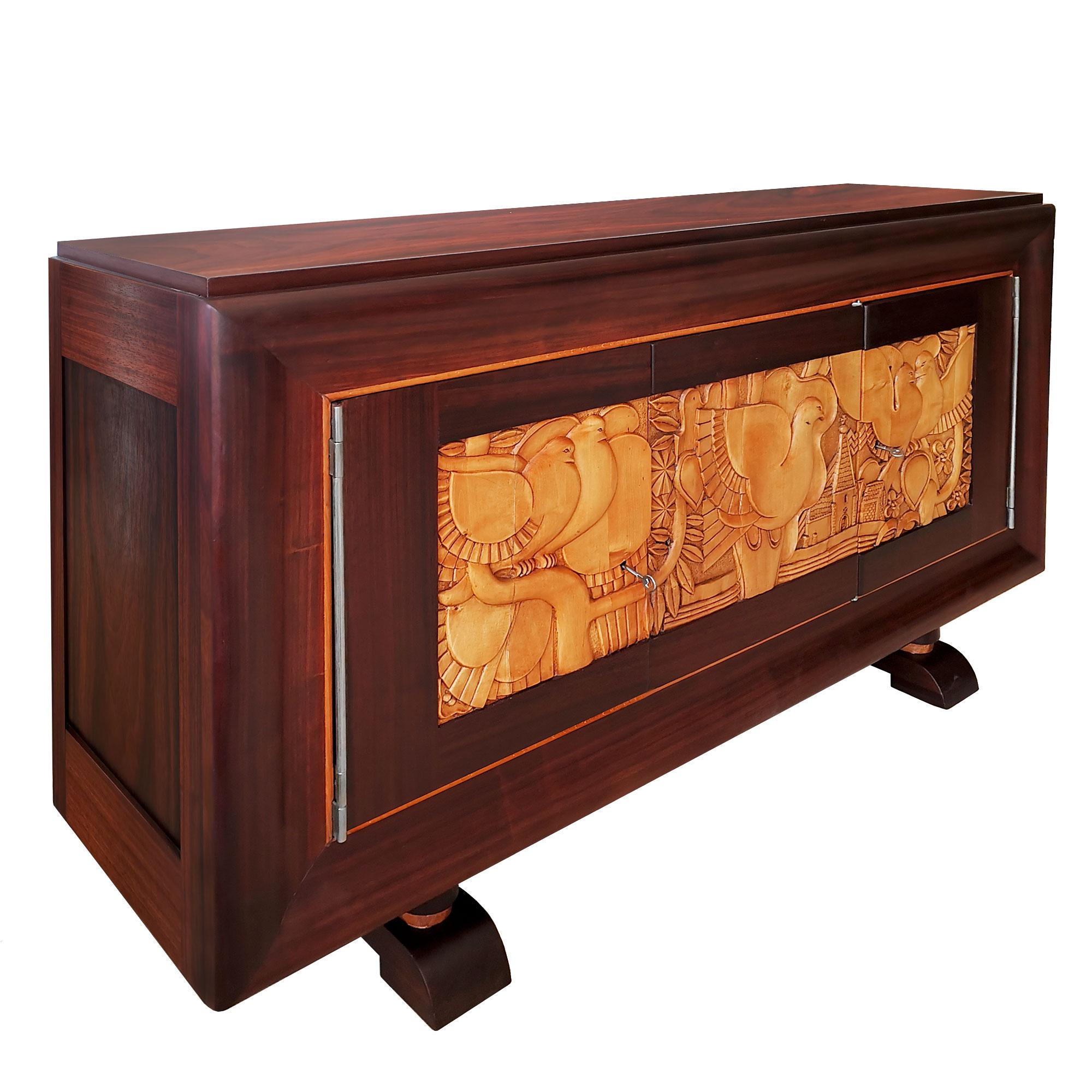 Sideboard with three doors, solid bubinga wood with bubinga veneer. Doors decoration in carved maple with doves, church tower and vegetal patterns. Bubinga shelves on the sides and maple shelf in the middle. Nickel plated bronze hinges. Shellac and