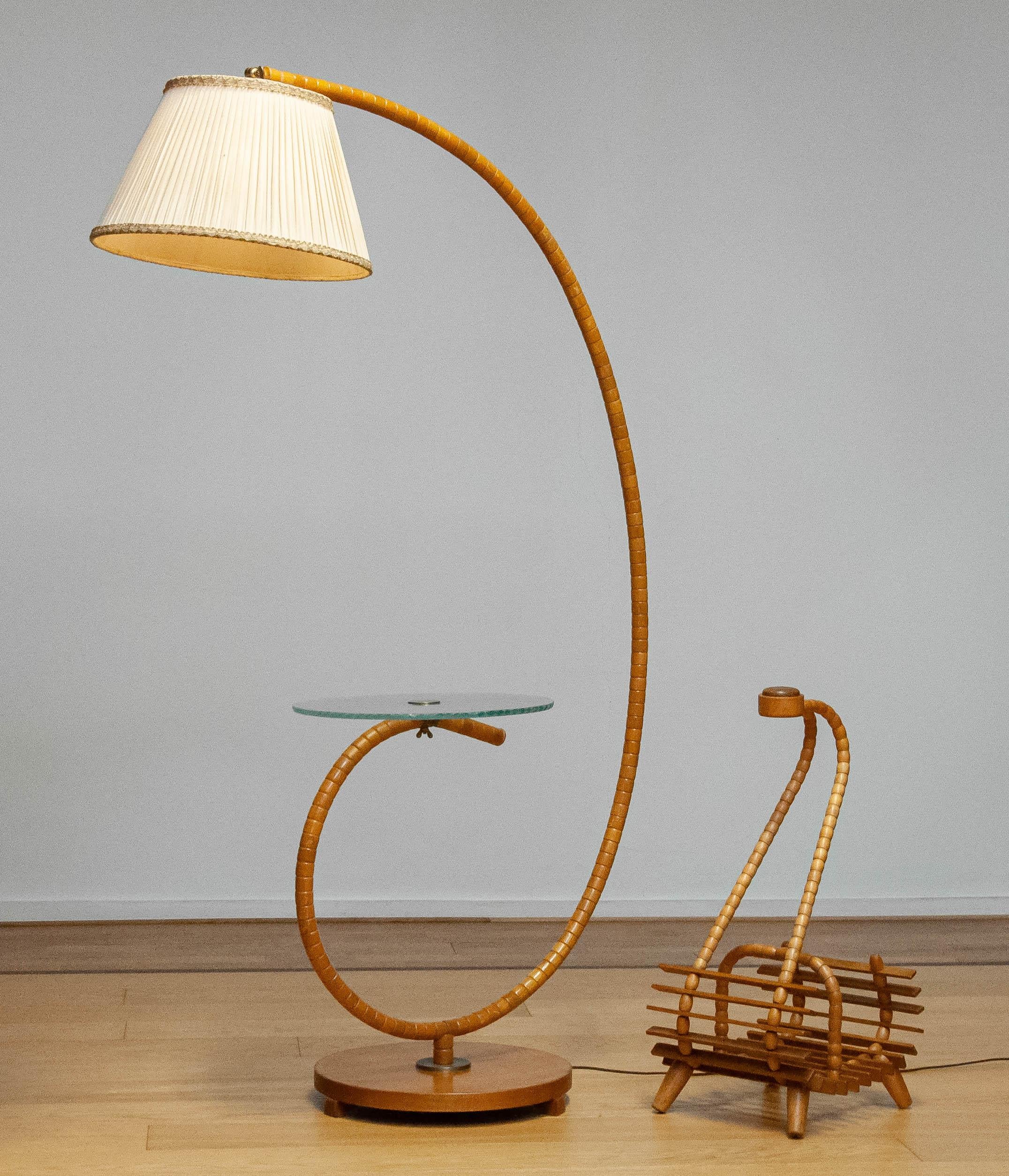 Absolutely beautiful and very rare Art Nouveau floor lamp made in the 1940s in Sweden by IWO in Mariestad Sweden with a matching 'Swedish' magazine rack. 
The lamp is made of Elm wood combined with the original art glass table. The art glass table