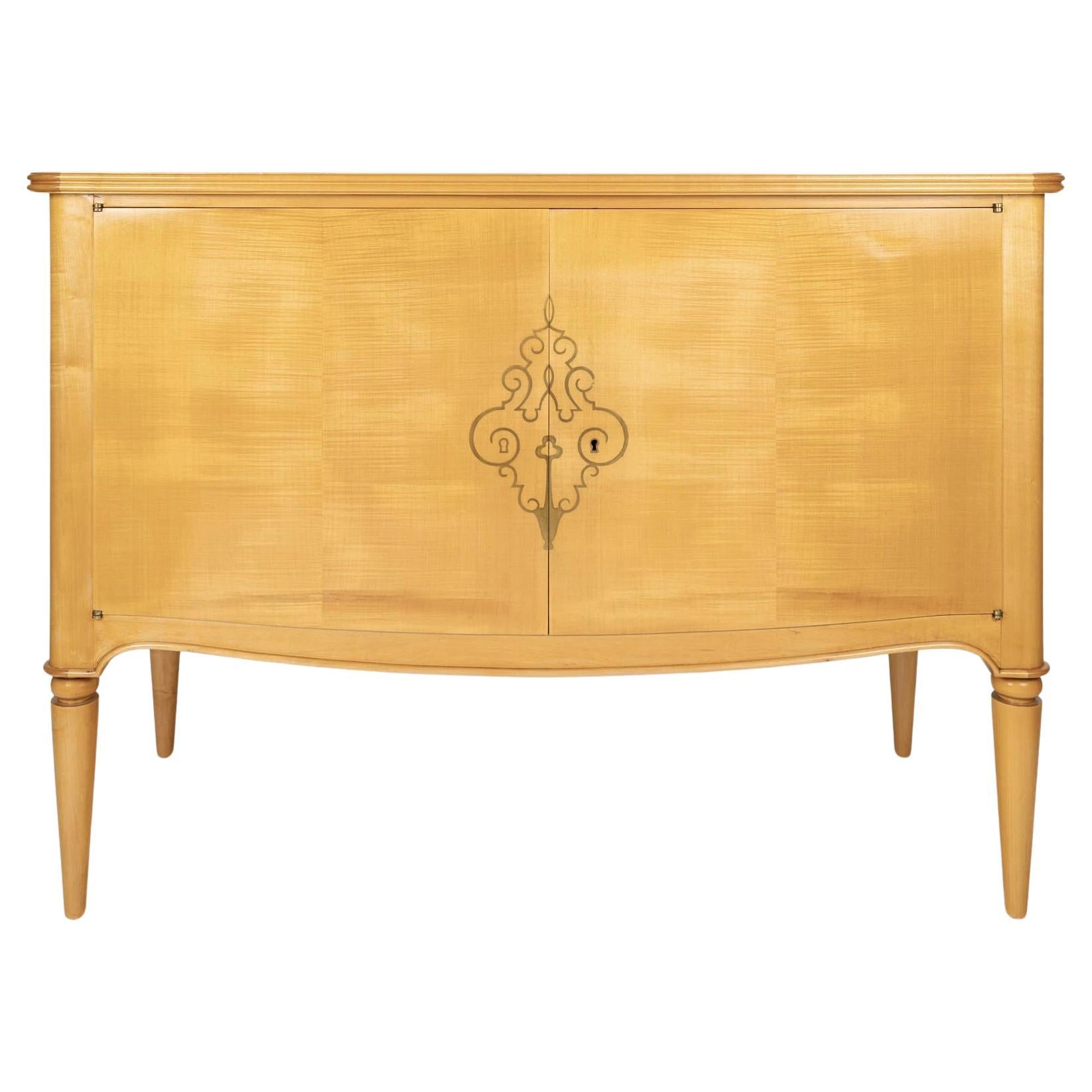 Beautiful sycamore chest of drawers, decorated with a gilded brass medallion, commissioned from René Prou by a private owner in the late 1940s.
Composed of a rectangular body, scalloped and highlighted by a rib running on 3 sides in the lower