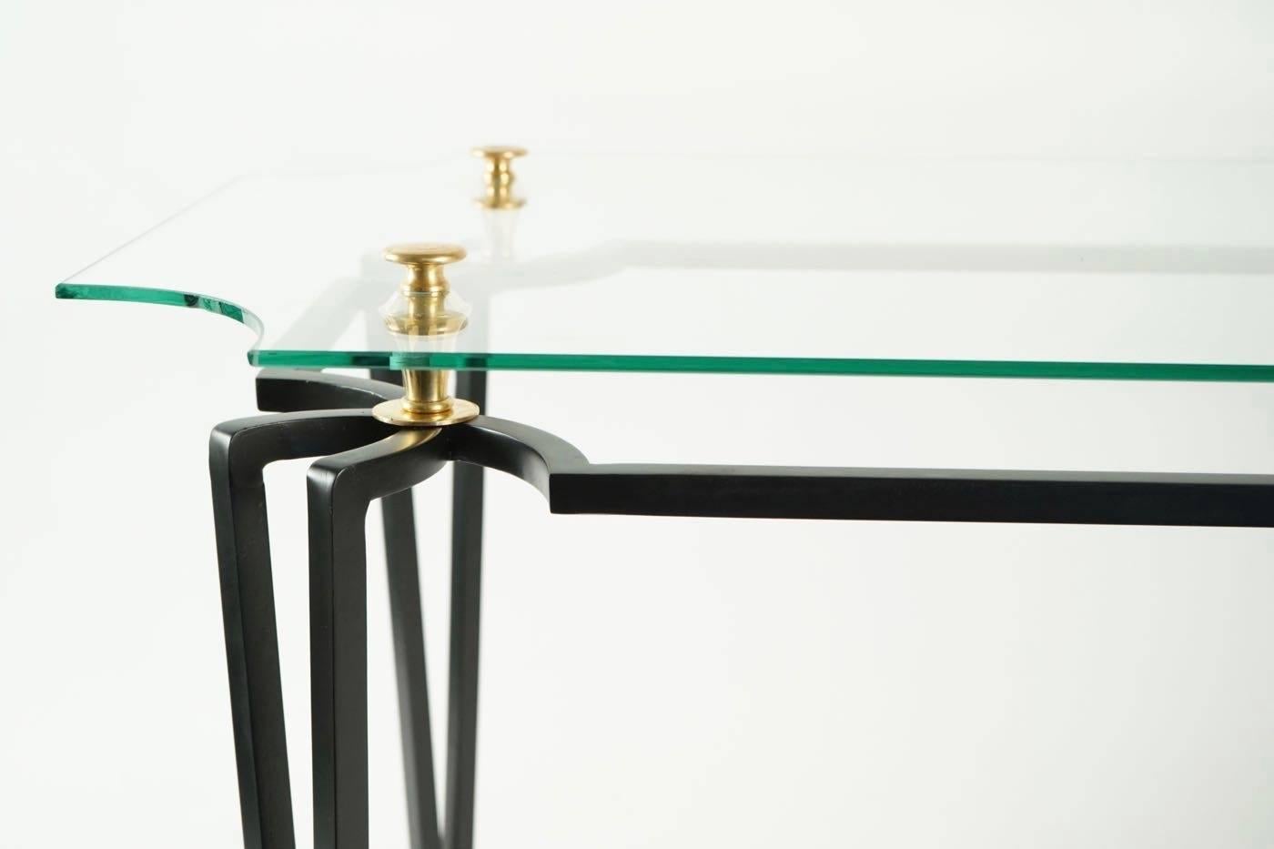 1940 wrought iron low table.
Structure made of black lacquered wrought iron. 
The glass top is mounted on four brass columns.
 