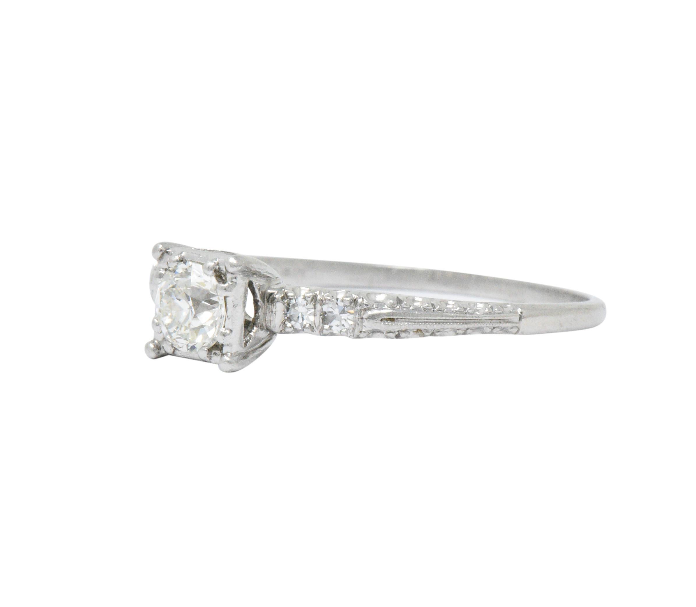 Centering an old European cut diamond weighing approximately 0.45 carat, J color and VS clarity 

Flanked by single cut diamonds weighing approximately 0.08 carat total, G/H color and VS clarity

Square form head with bead set center diamond and