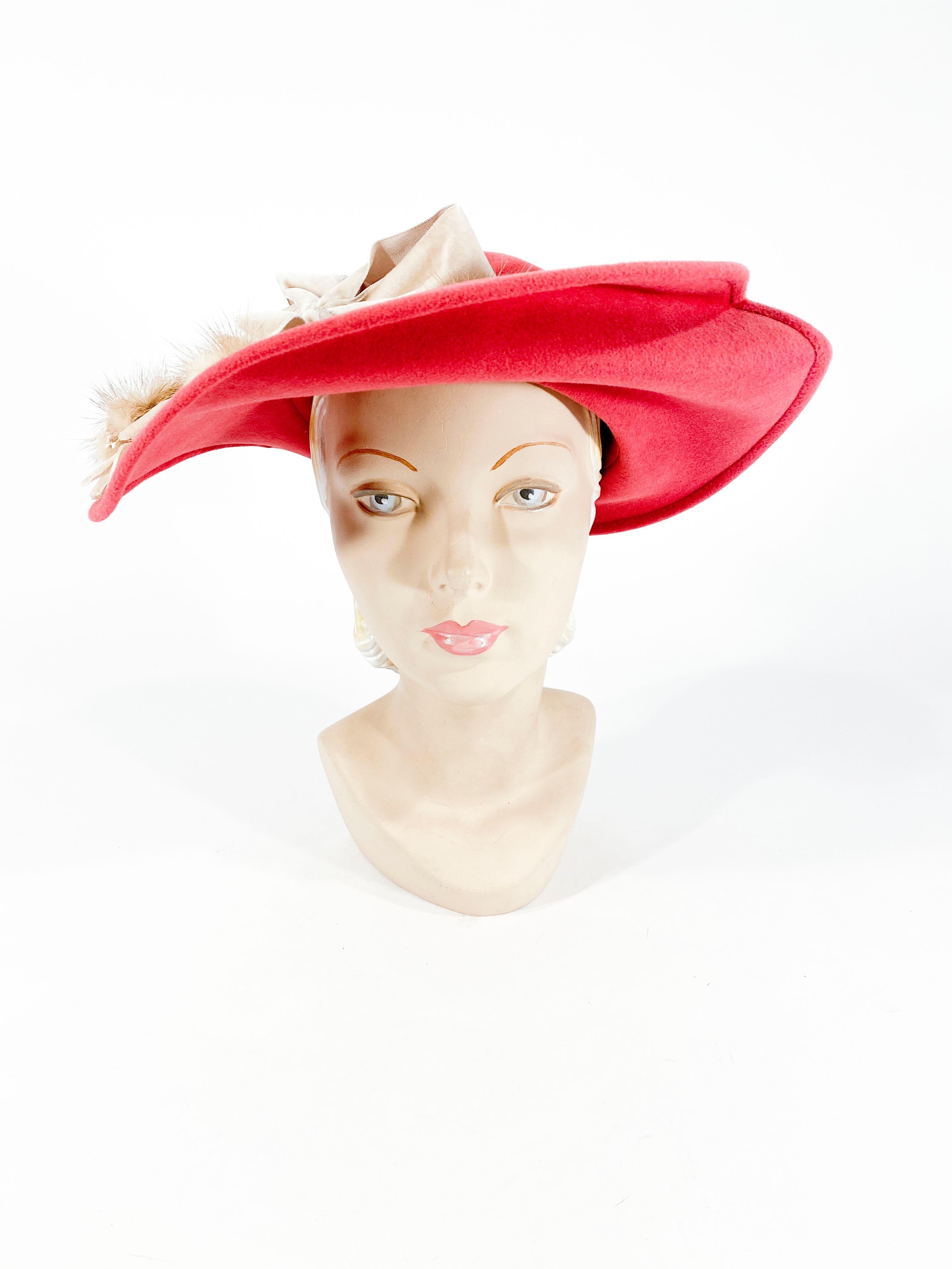 Late 1940s to early 1950s deep rose colored fur felt picture hat with a wide brim hand sculpted into an asymmetrical frame. The crown of the hat has a velvet bow adorned with velvet and mink flowers that decorated the entire side of the brim.